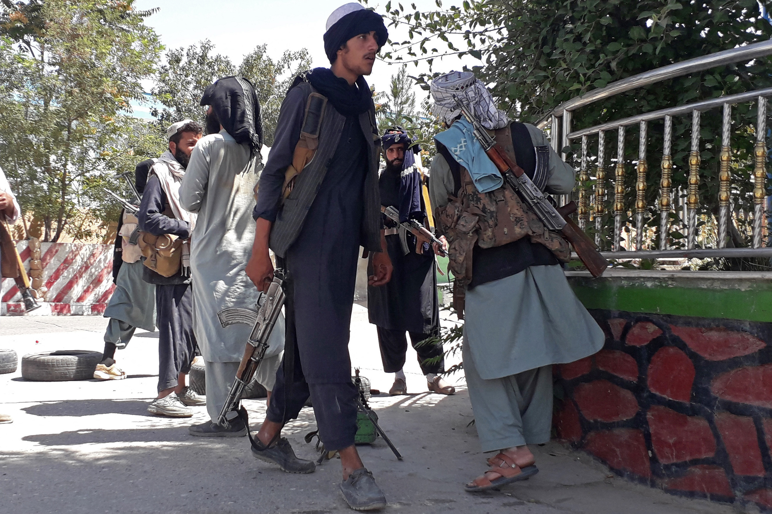 Taliban fighters are seen standing along the roadside in Ghazni on August 12, 2021 after taking the city [AFP]