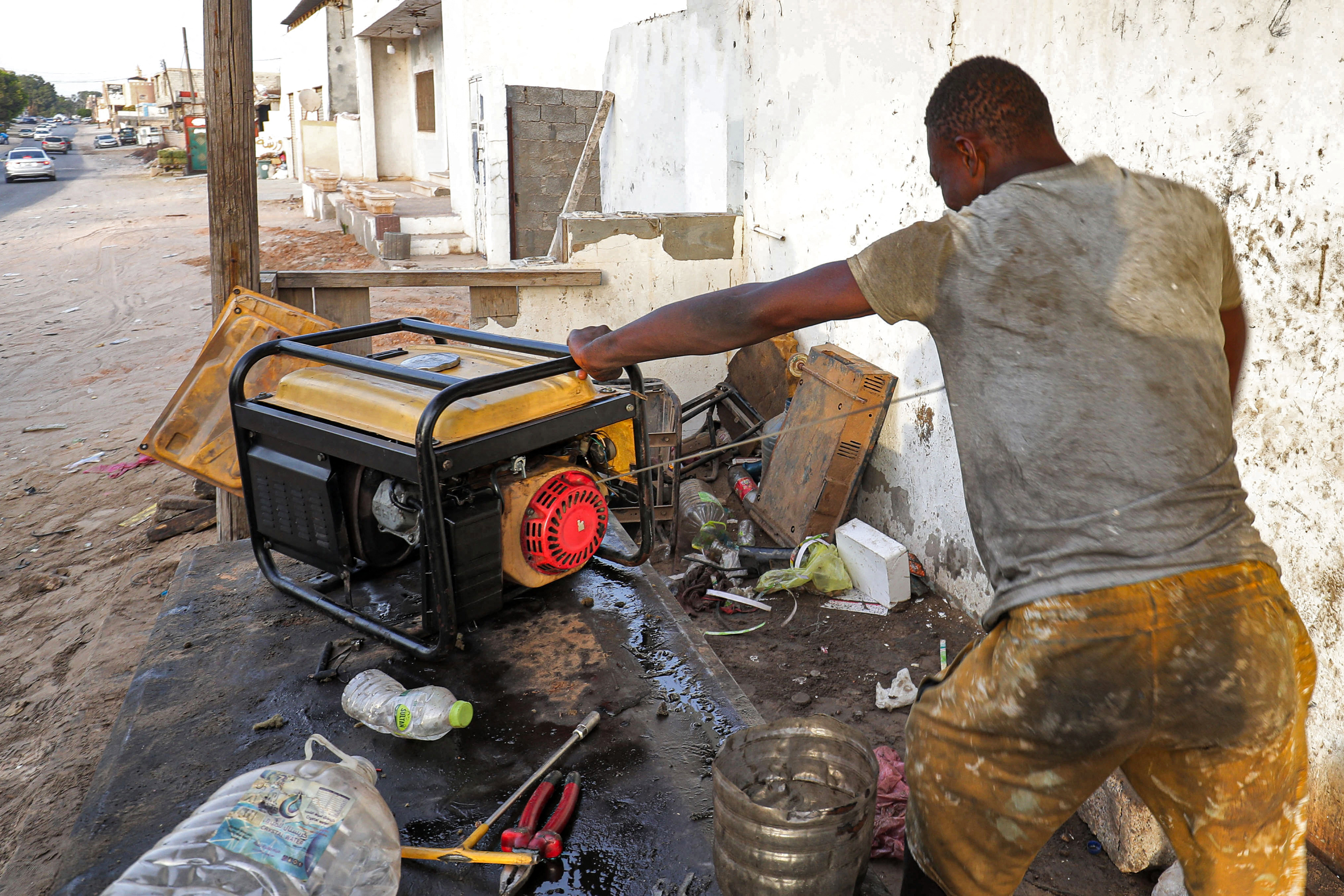 A technician works on the maintenance of an electric power generator outside a shop in Libya&#39;s capital Tripoli [Mahmud Turkia/AFP]