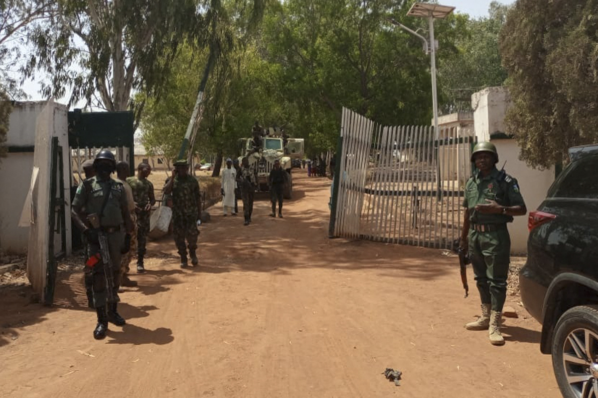 Nigerian soldiers and police officers stand at the entrance of the Federal College of Forestry Mechanisation in Mando, Kaduna state, on March 12, 2021, after a gang stormed the school, taking at least 30 students around 9:30pm (20:30 GMT) on March 11, 2021 [File: Bosan Yakusak/AFP]