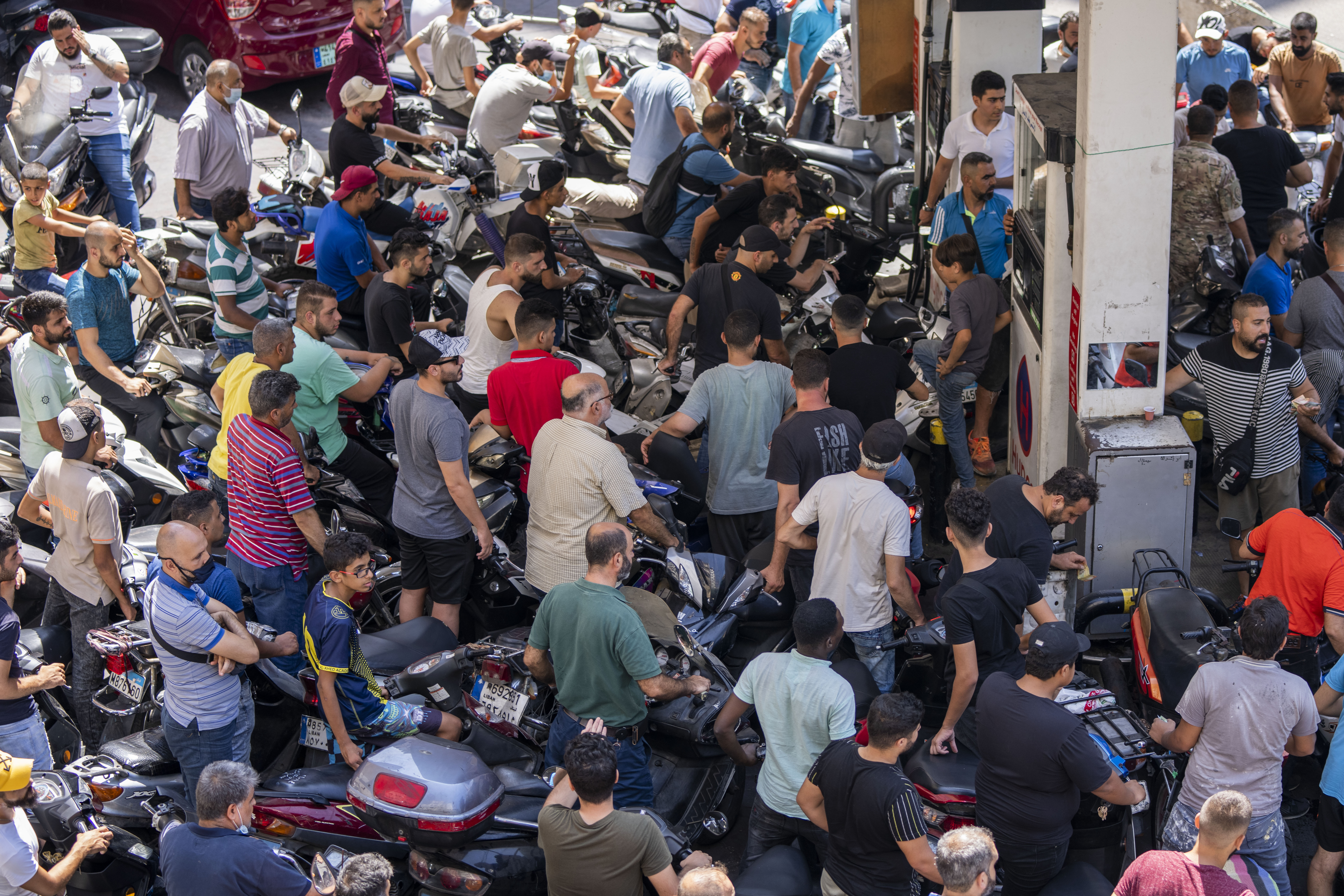 Motorcycle drivers wait to get fuel at a gas station in Beirut [File: Hassan Ammar/AP Photo]