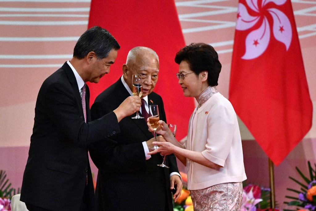 Former Hong Kong chief executives CY Leung, left, and Tung Chee-hwa, centre, toast with current leader Carrie Lam during the 23rd anniversary of Hong Kong&#39;s handover from Britain to China last year [File: Anthony Wallace/AFP]