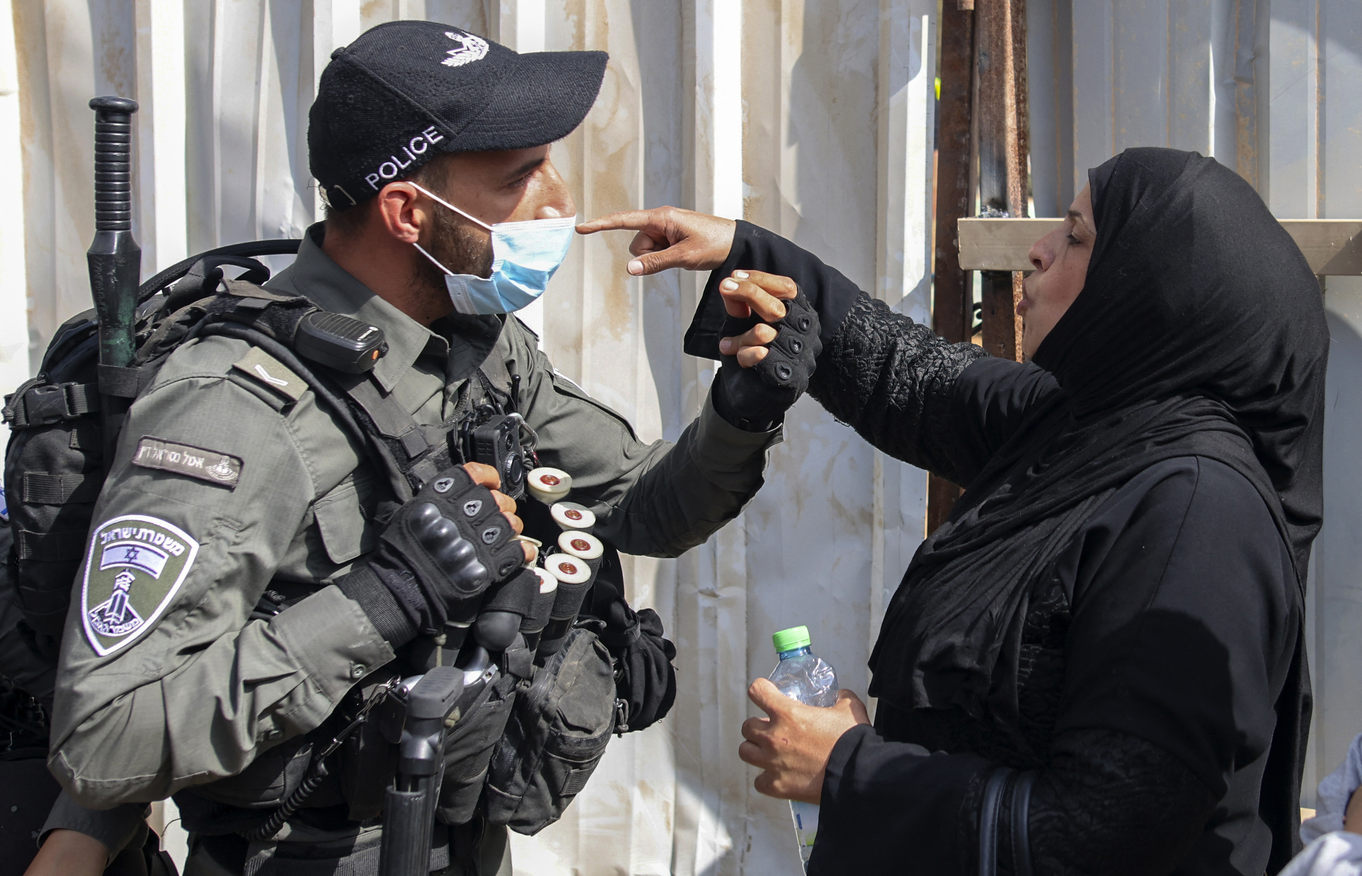 A Palestinian woman confronts Israeli army officers at the Al-Yousufiya Cemetery near the Lion&#39;s Gate entrance to the Al-Aqsa Mosque compound in East Jerusalem [Ahmad Gharabli/AFP]
