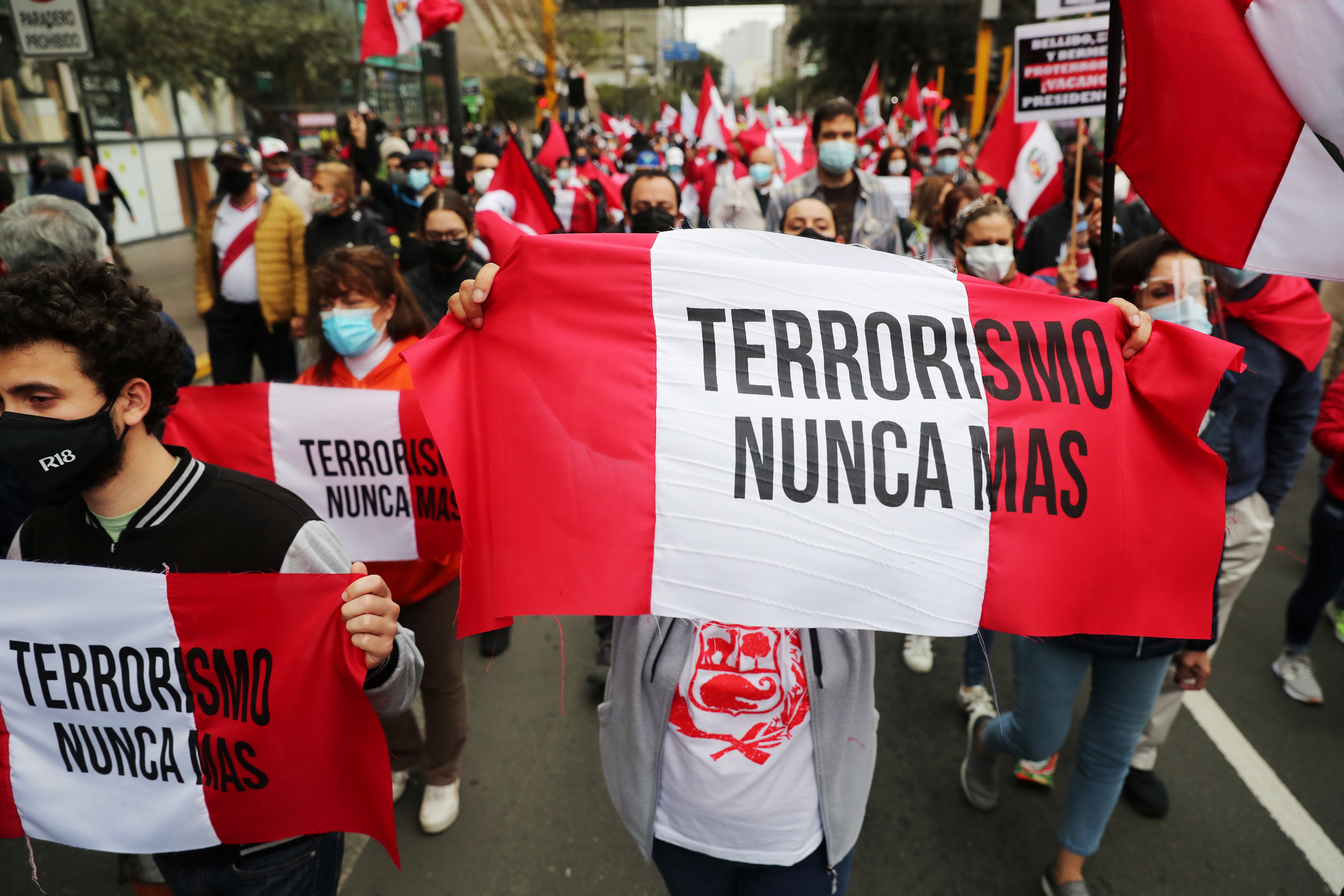 People holding banners reading &#39;Terrorism never again&#39; gather to commemorate the 29th anniversary of the capture of Abimael Guzman, founder of Shining Path, in Lima, Peru on September 12, 2021 [Sebastian Castaneda/Reuters]