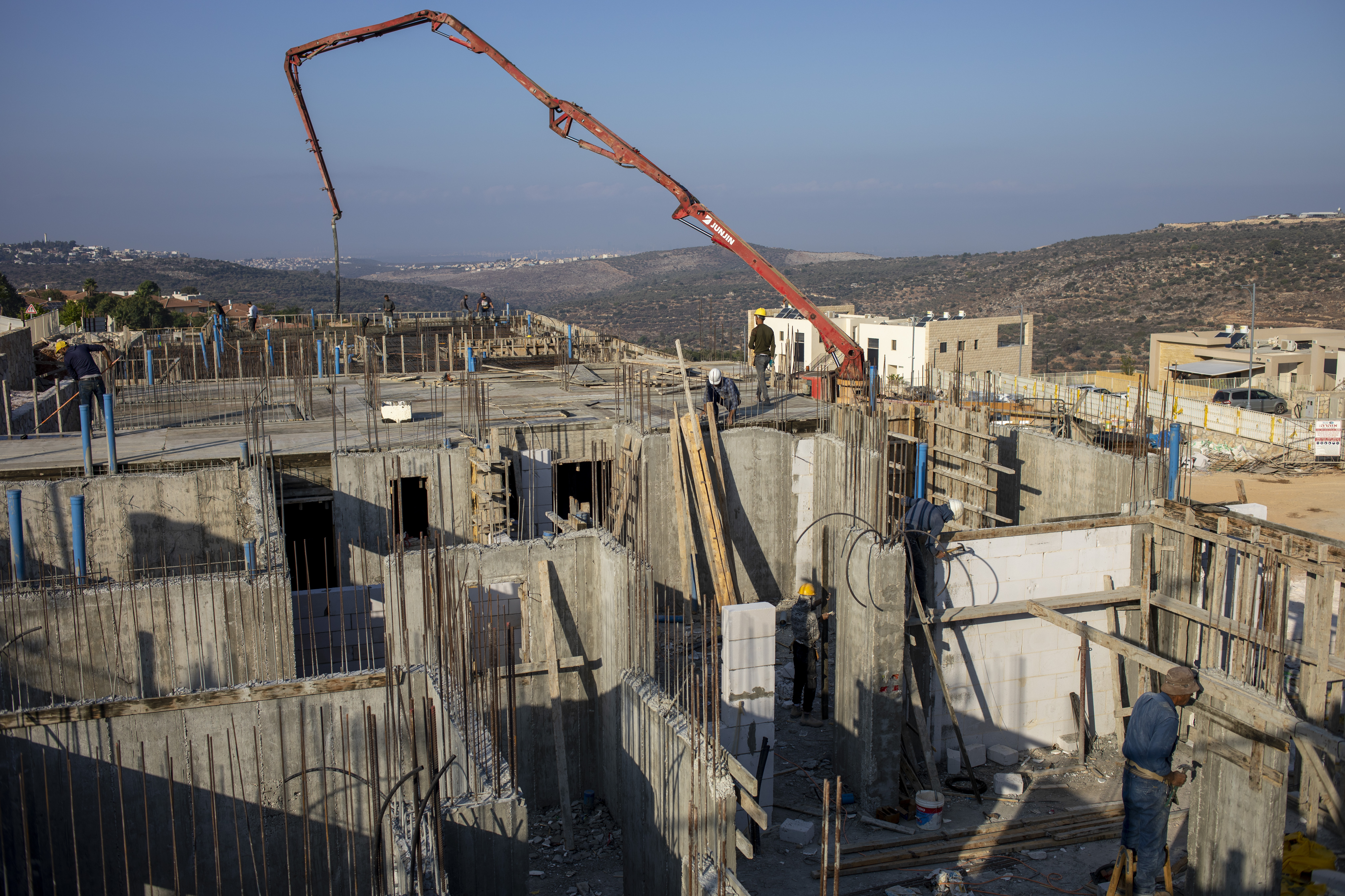 Palestinian labourers work building new houses in the West Bank Jewish settlement of Bruchin near the Palestinian town of Nablus [File: Ariel Schalit/AP]
