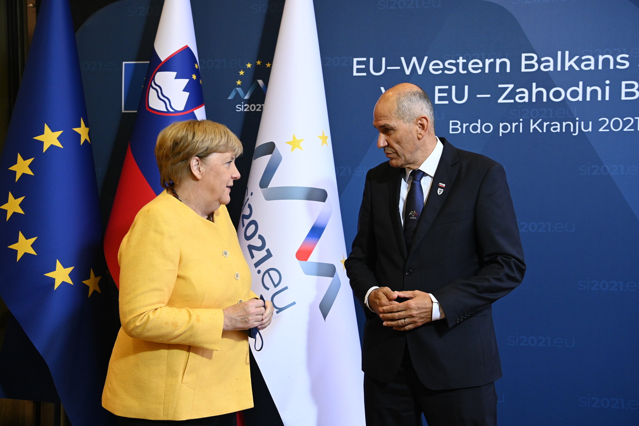 Slovenia&#39;s Prime Minister Janez Jansa (R) welcomes Germany&#39;s Chancellor Angela Merkel (L) for the EU-Western Balkans summit at Brdo Congress Centre, in Brdo pri Kranju, in Kranj, Slovenia, on October 6, 2021. [Photo by Government of Slovenia/Handout via Getty Images]
