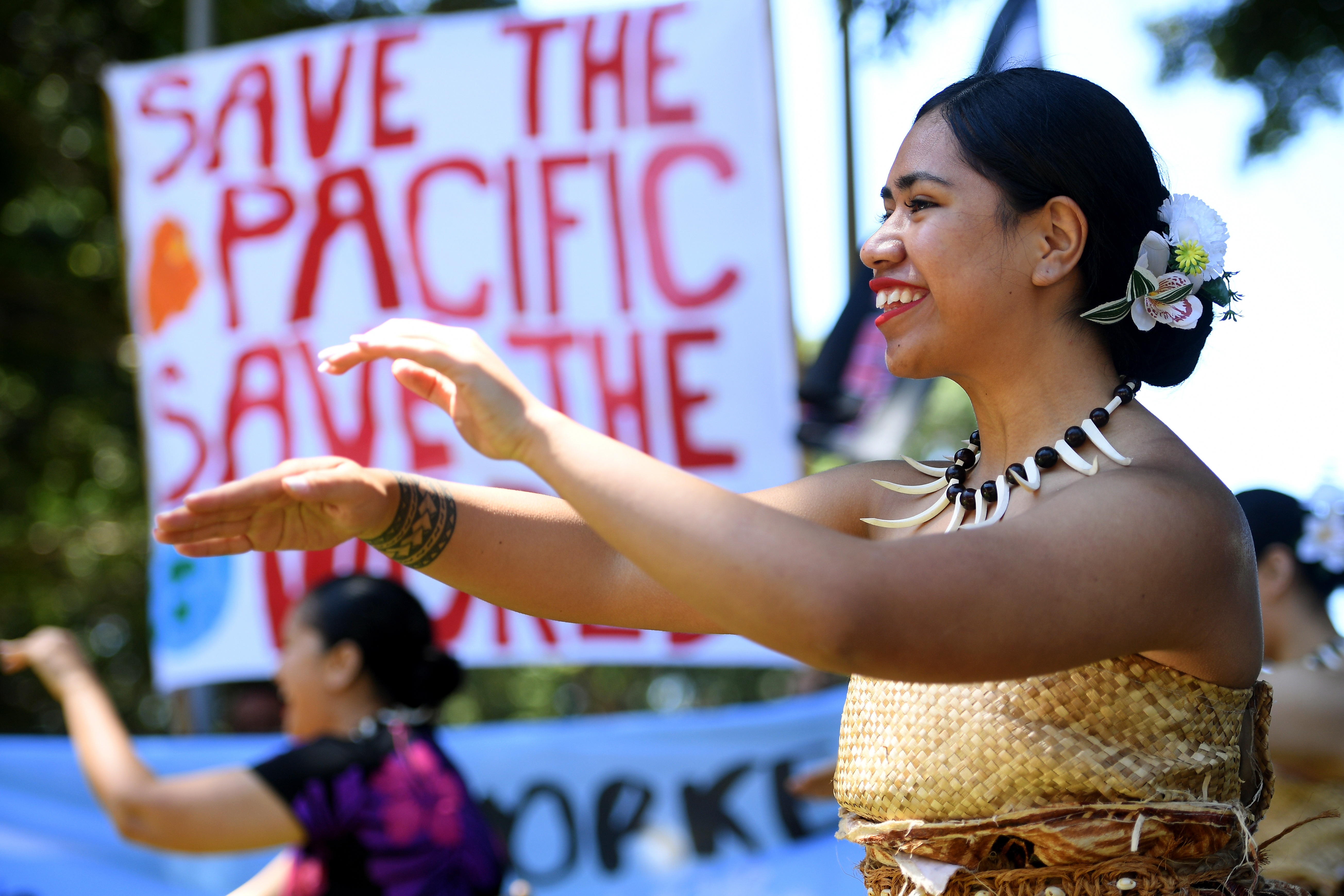 Pacific island dancers join a rally to call for climate action held in Sydney during COP26 [File: Dan Himbrechts/EPA]