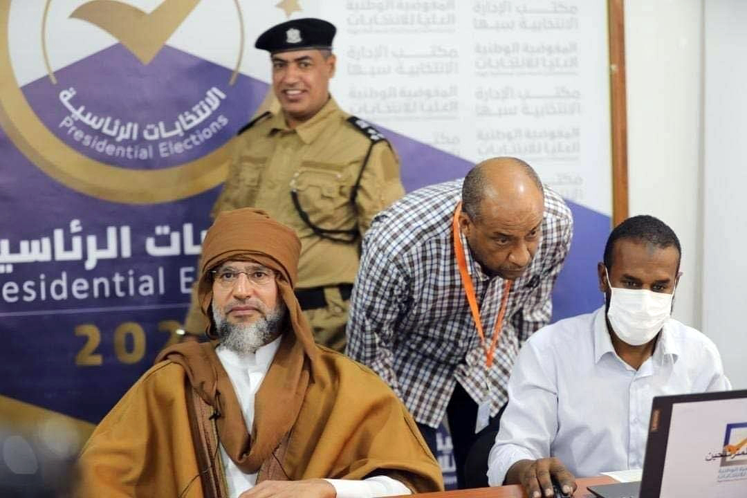 A handout photo made available by the Libyan High National Election Commission Facebook page on November 14, 2021 shows Saif al-Islam Gaddafi (L), son of the former Libyan leader Muammar Gaddafi, registering to run in upcoming presidential elections, in the city of Sebha, south of Tripoli, Libya [Libyan High National Election Commission Handout via EPA]