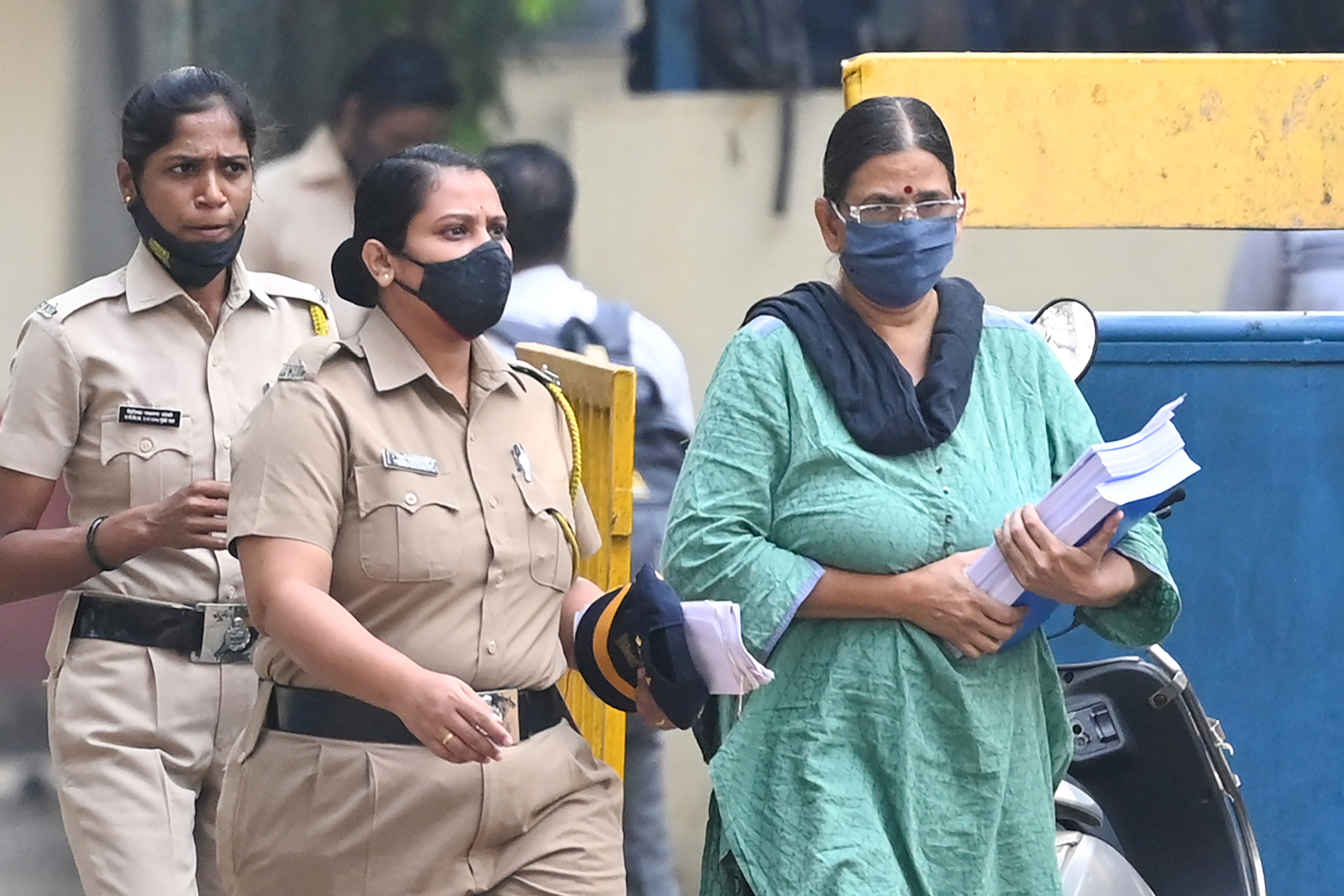 Police escort activist and lawyer Sudha Bharadwaj towards a van as she leaves jail to appear in a special court ahead of her release on bail on the 2018 Bhima-Koregaon case, in Mumbai [Punit Paranjpe/AFP]