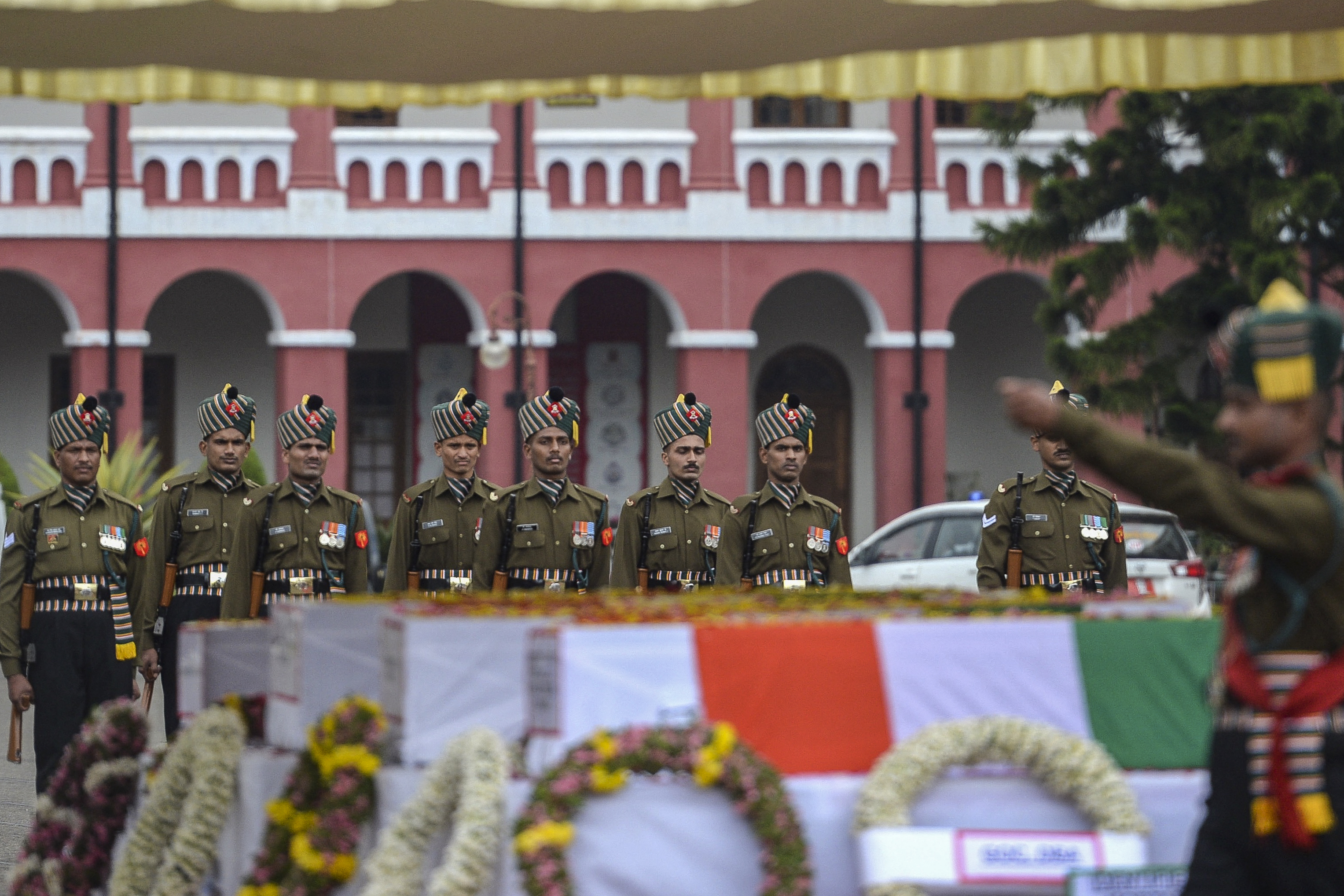 Soldiers pay respects in front of the coffins of Indian defence chief General Bipin Rawat and 12 others who died in a helicopter crash, at the Madras regimental centre in Wellington, Tamil Nadu state [Arun Sankar/AFP]