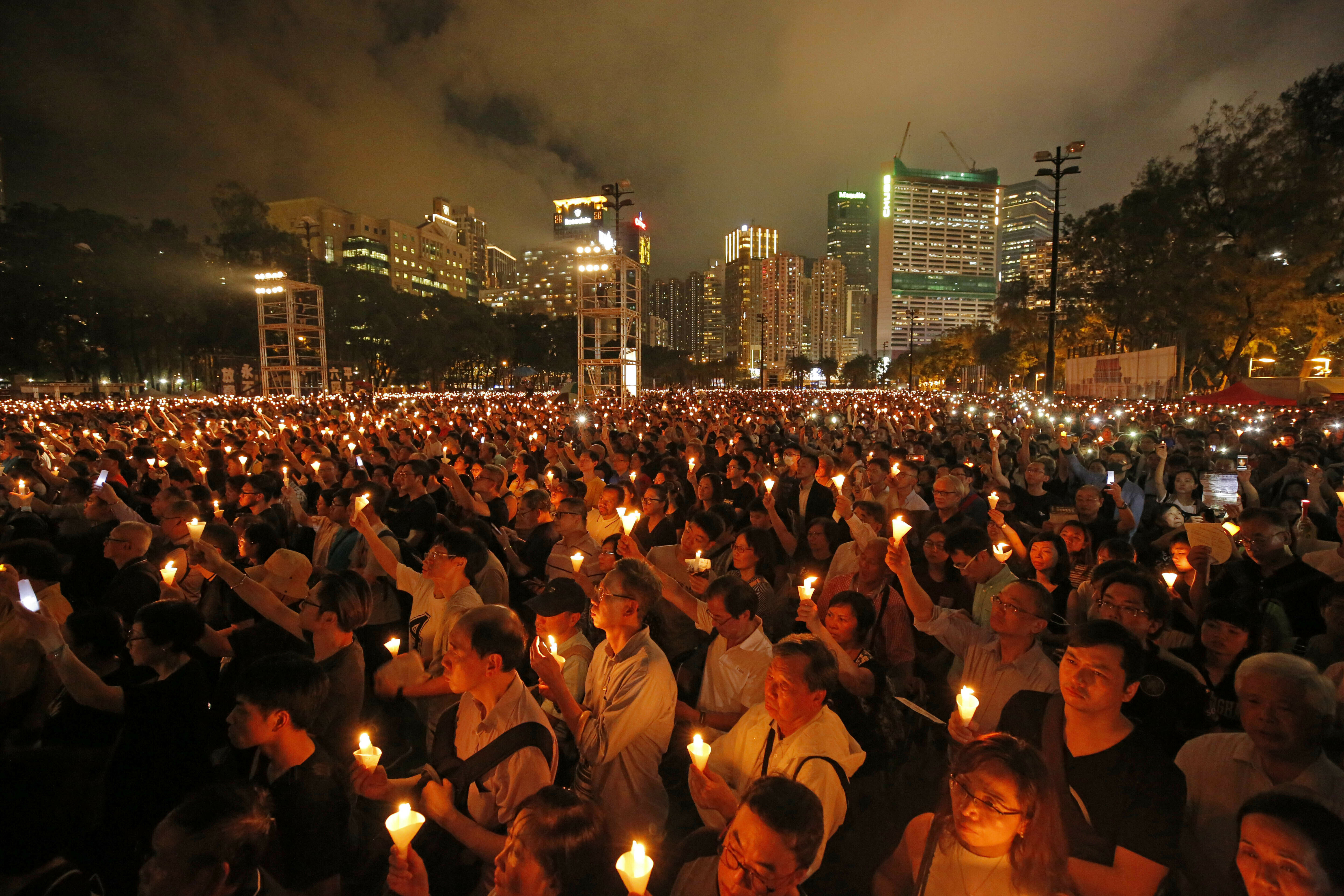 FILE - In this June 4, 2019, file photo, thousands of people attend a candlelight vigil for victims of the Chinese government's brutal military crackdown three decades ago on protesters in Beijing's Tiananmen Square at Victoria Park in Hong Kong. Nine Hong Kong activists and ex-lawmakers were handed jail sentences of up to 10 months Wednesday, Sept. 15, 2021, over their roles in last year's banned Tiananmen candlelight vigil, the latest blow in an ongoing crackdown on dissent in Hong Kong. (AP Photo/Kin Cheung, File)