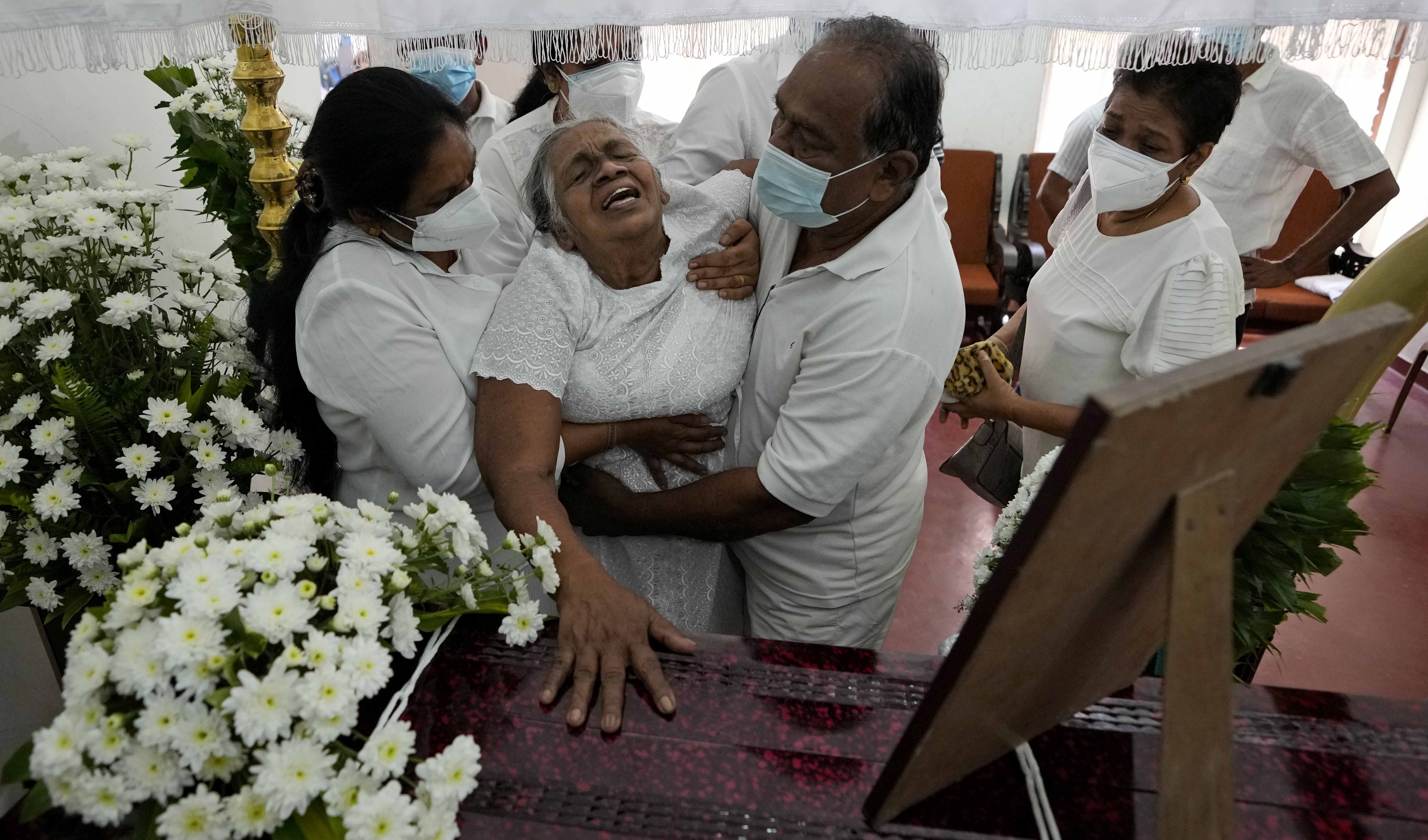 Diyawadana&#39;s mother grieves at her son&#39;s coffin after his body was returned to Sri Lanka [Eranga Jayawardena/AP Photo]
