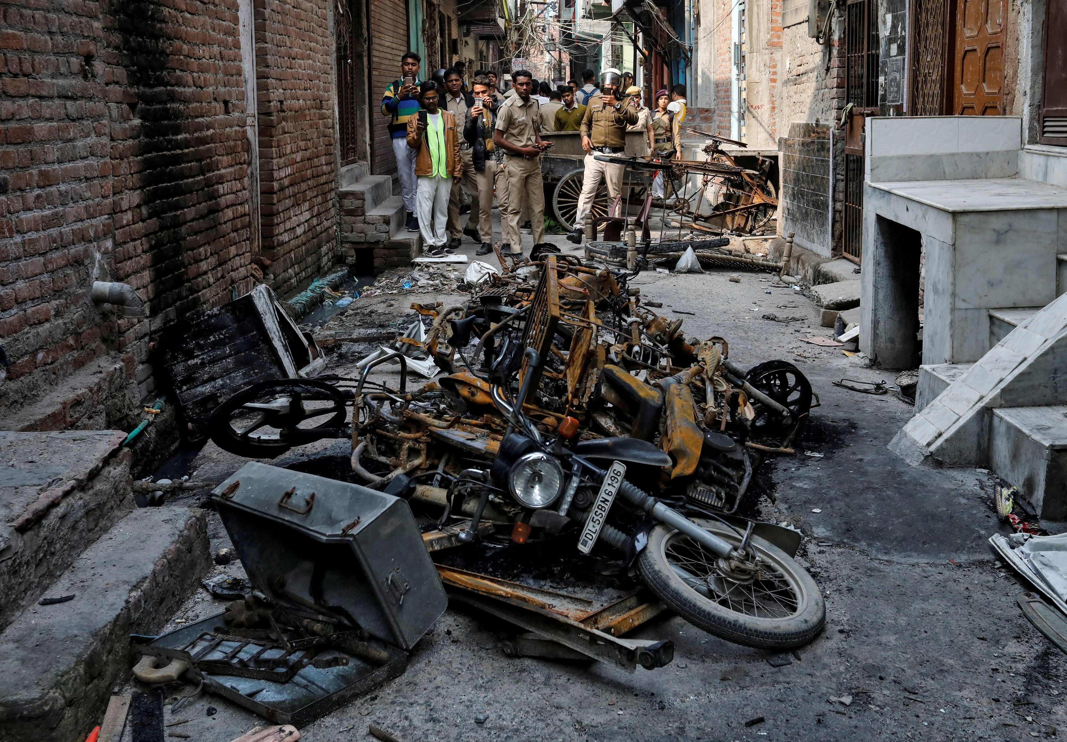 Police photograph burnt-out property owned by Muslims in Delhi, India.