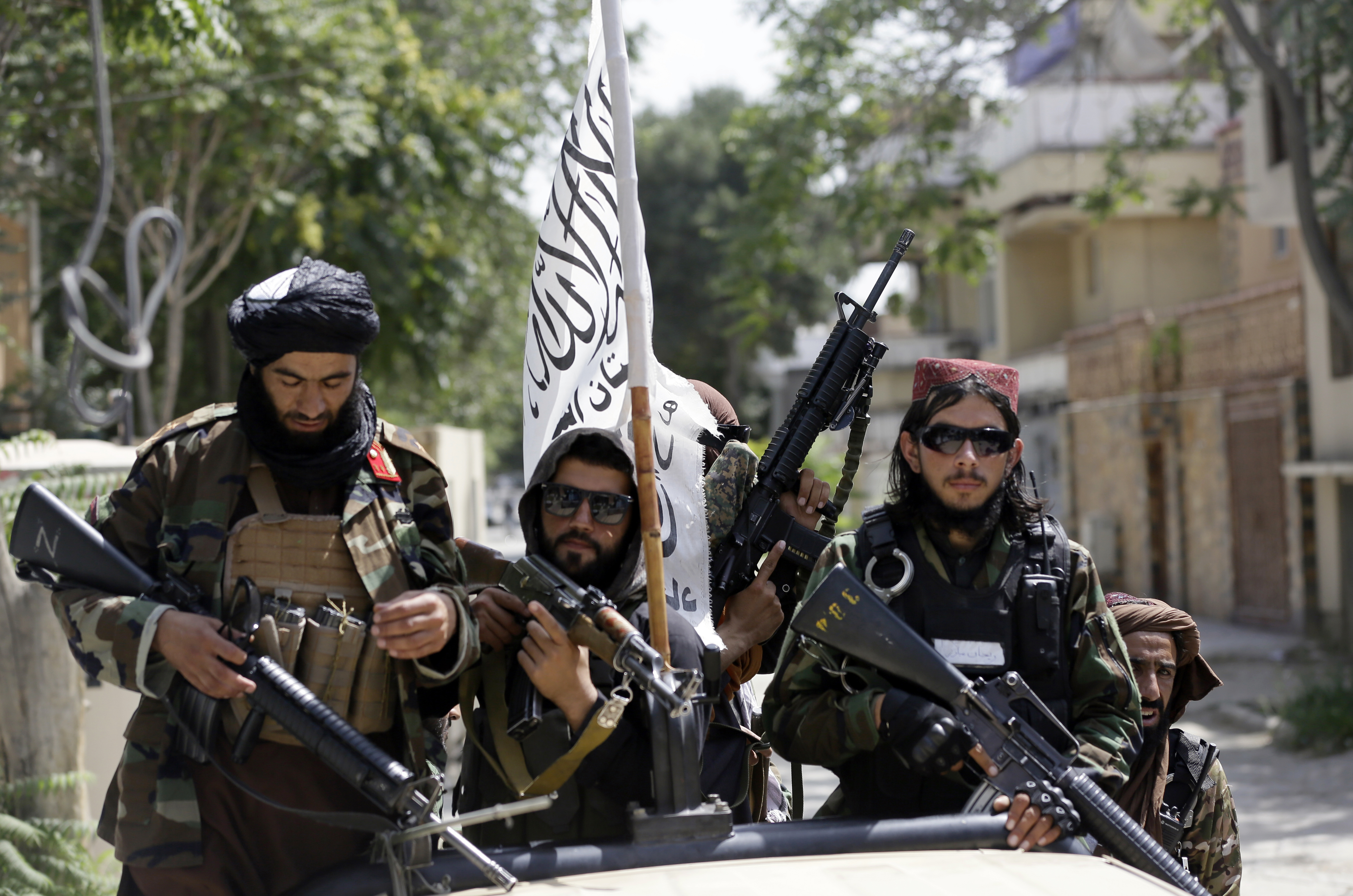 FILE - In this Aug. 19, 2021, file photo, Taliban fighters display their flag on patrol in Kabul, Afghanistan. The Taliban win in Afghanistan gave a boost to militants in neighboring Pakistan. The Pakistani Taliban, known as the TTP, have become emboldened in tribal areas along the border with Afghanistan. (AP Photo/Rahmat Gul, File)