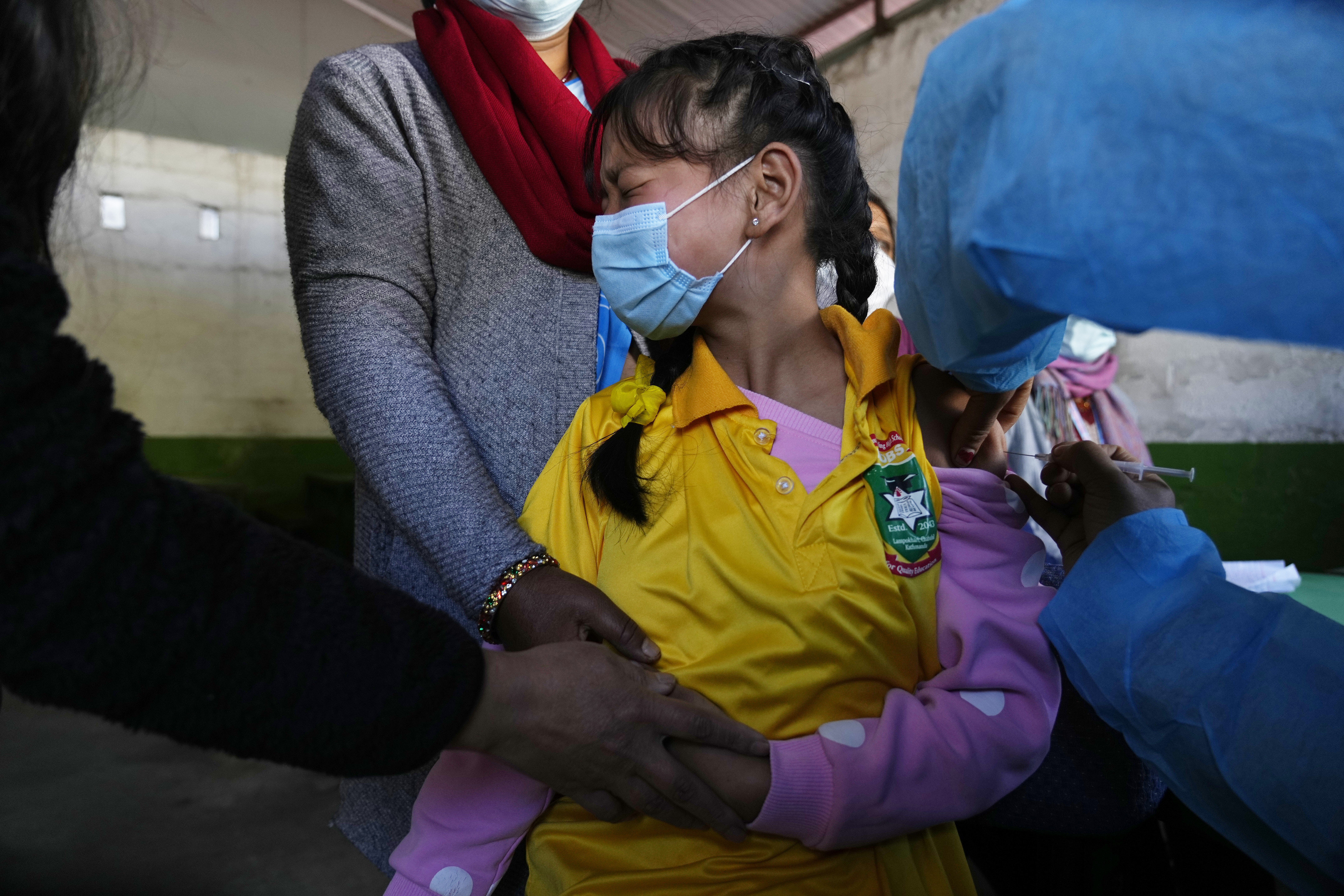 A Nepalese girl receives a dose of the Moderna vaccine for COVID-19 at her school in Kathmandu