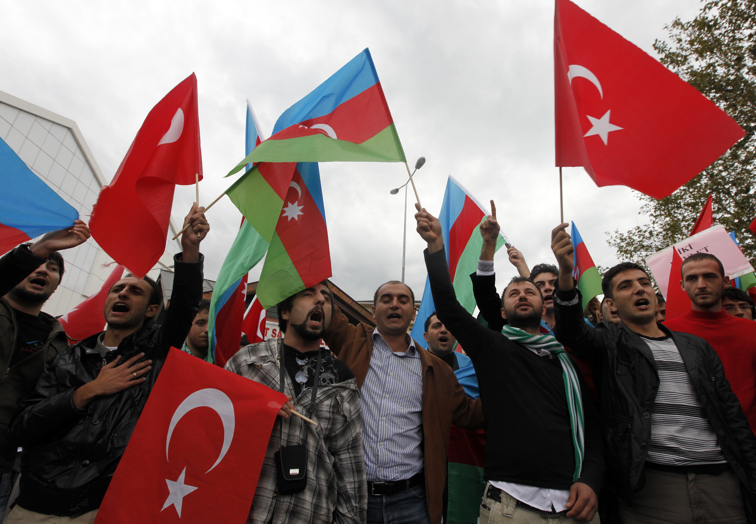 Demonstrators waving Turkey's and Azerbaijan's national flags protest aganist the agreement signed between Turkey and Armenia