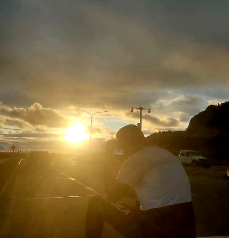 Refugee Yasir Omar silhouetted against. the sun,. He fled Sudan but was sent offshore after trying to reach Australia by boat. He is now in PNG