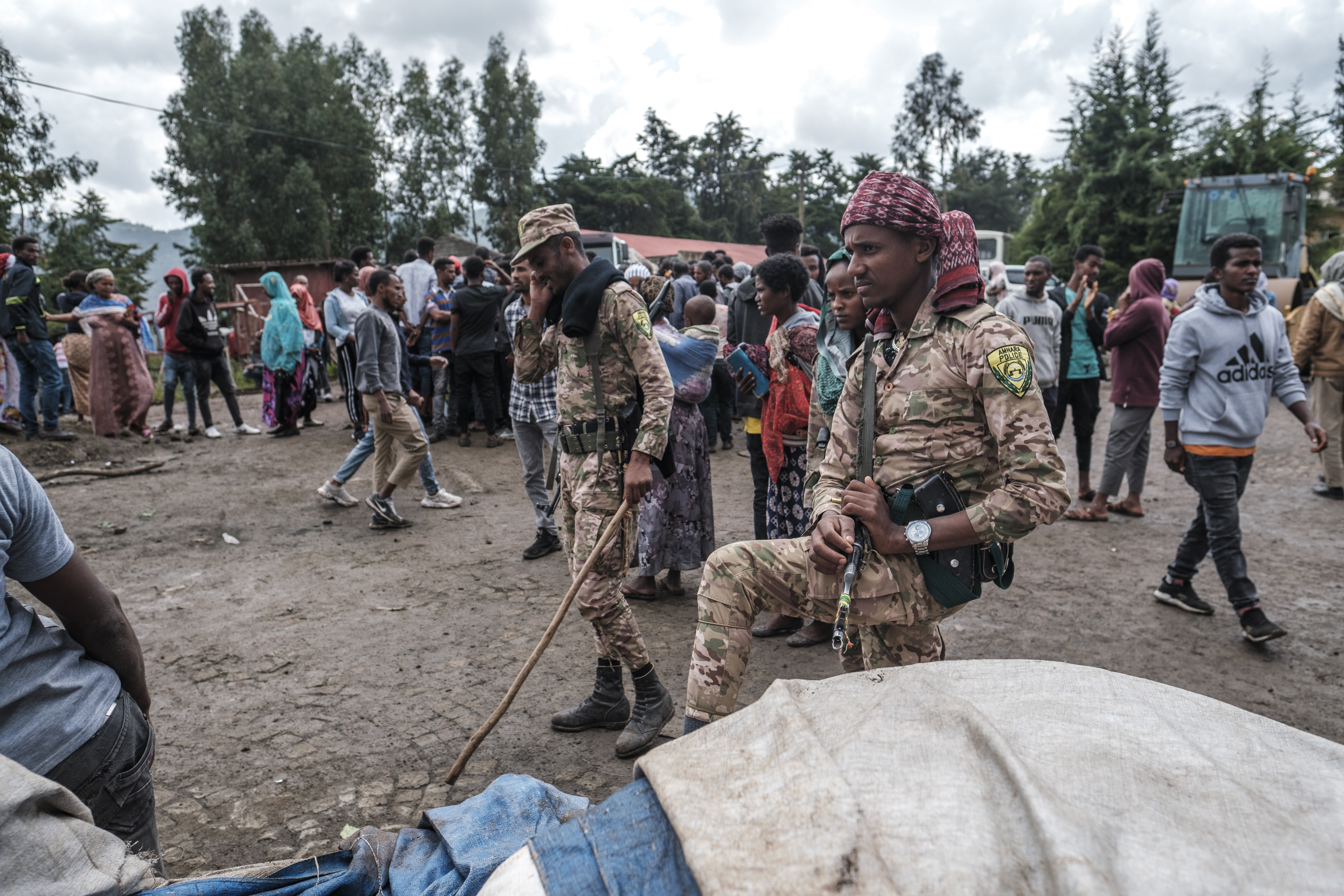 Members of special force of the Amhara police stand next to sacks of food during food distribution for internally displaced people from Amhara