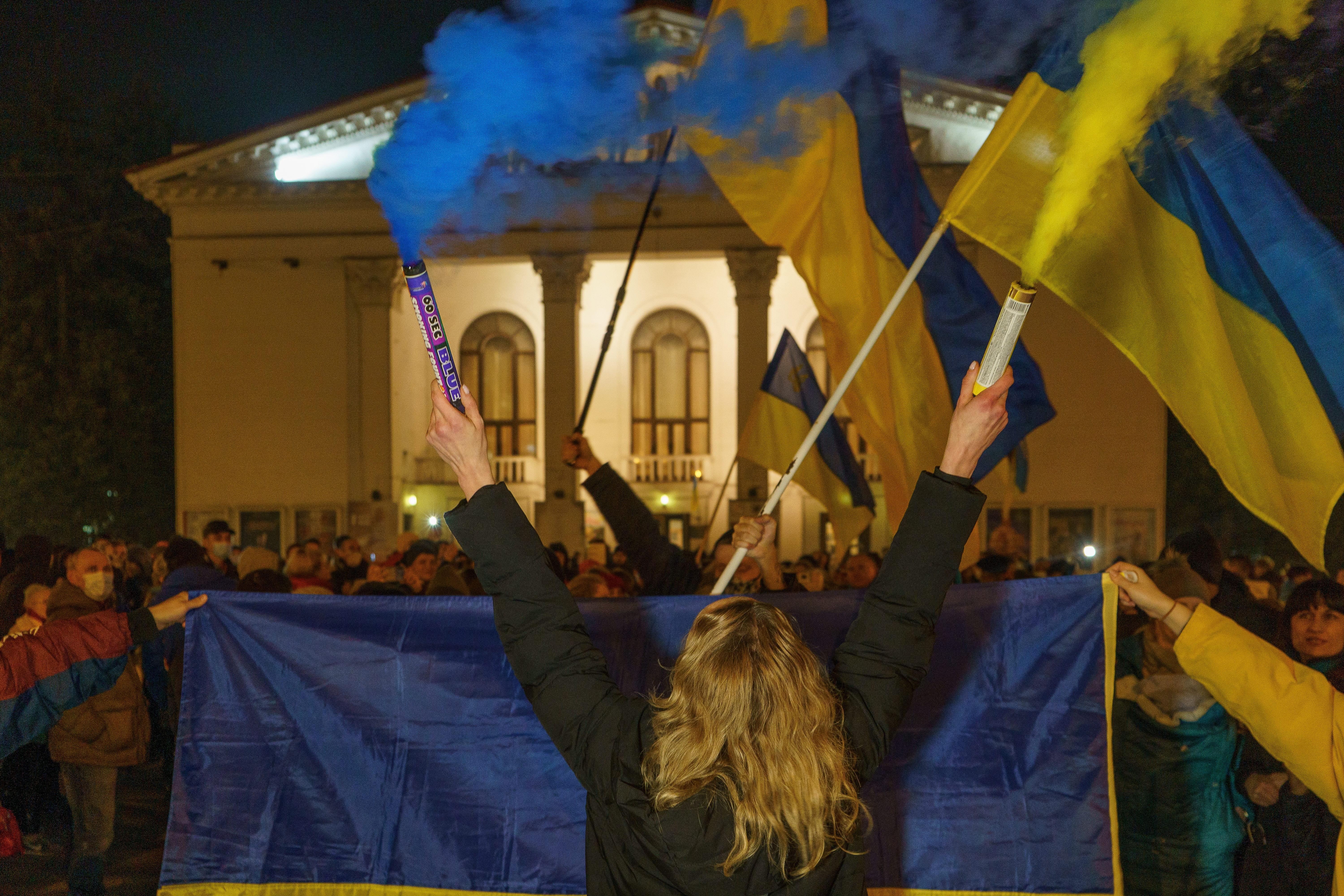 Diana Berg, an activist from Mariupol holding a pair of smoke bombs in Mariupol