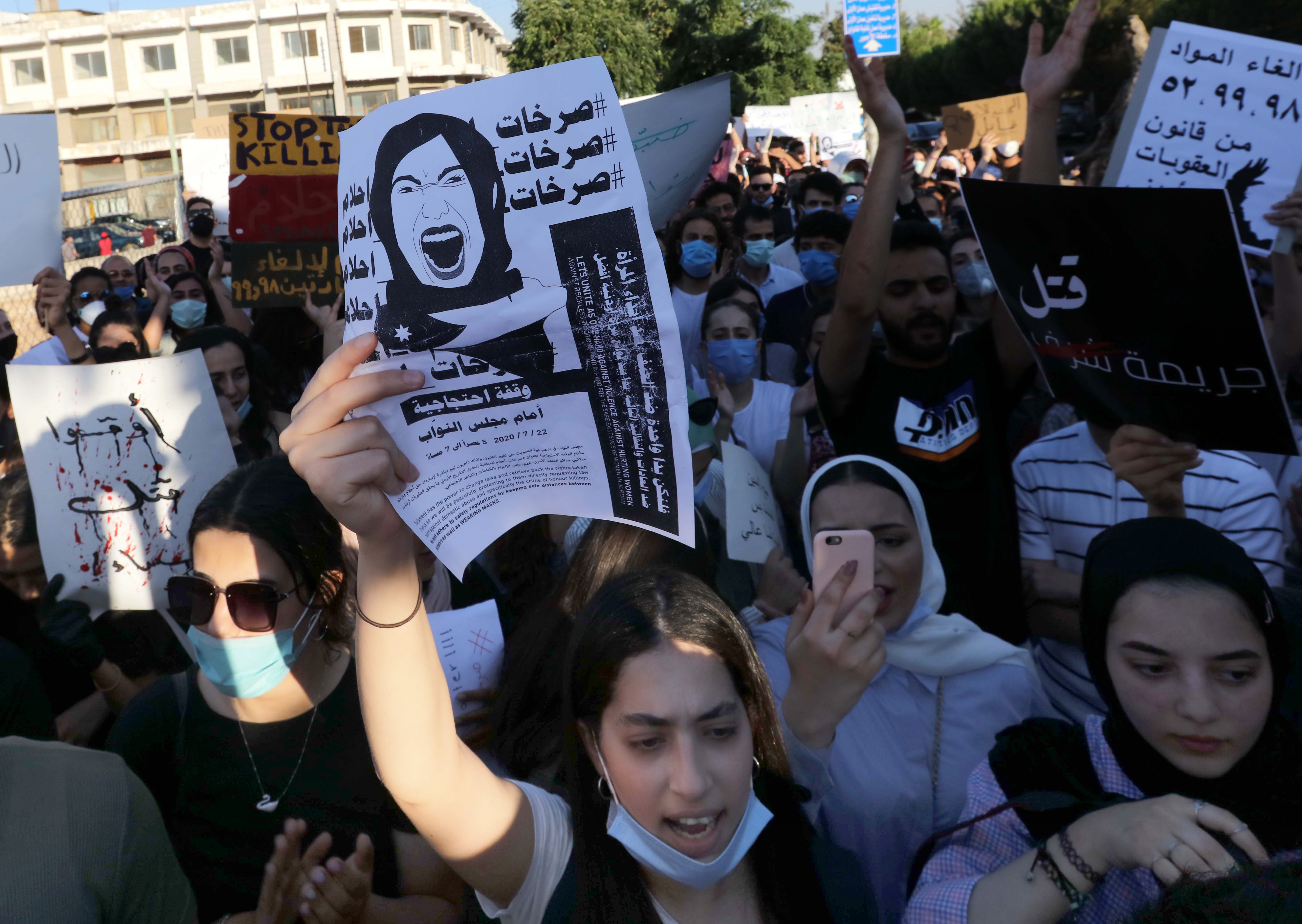 Women hold placards denouncing violence against women in Amman, Jordan