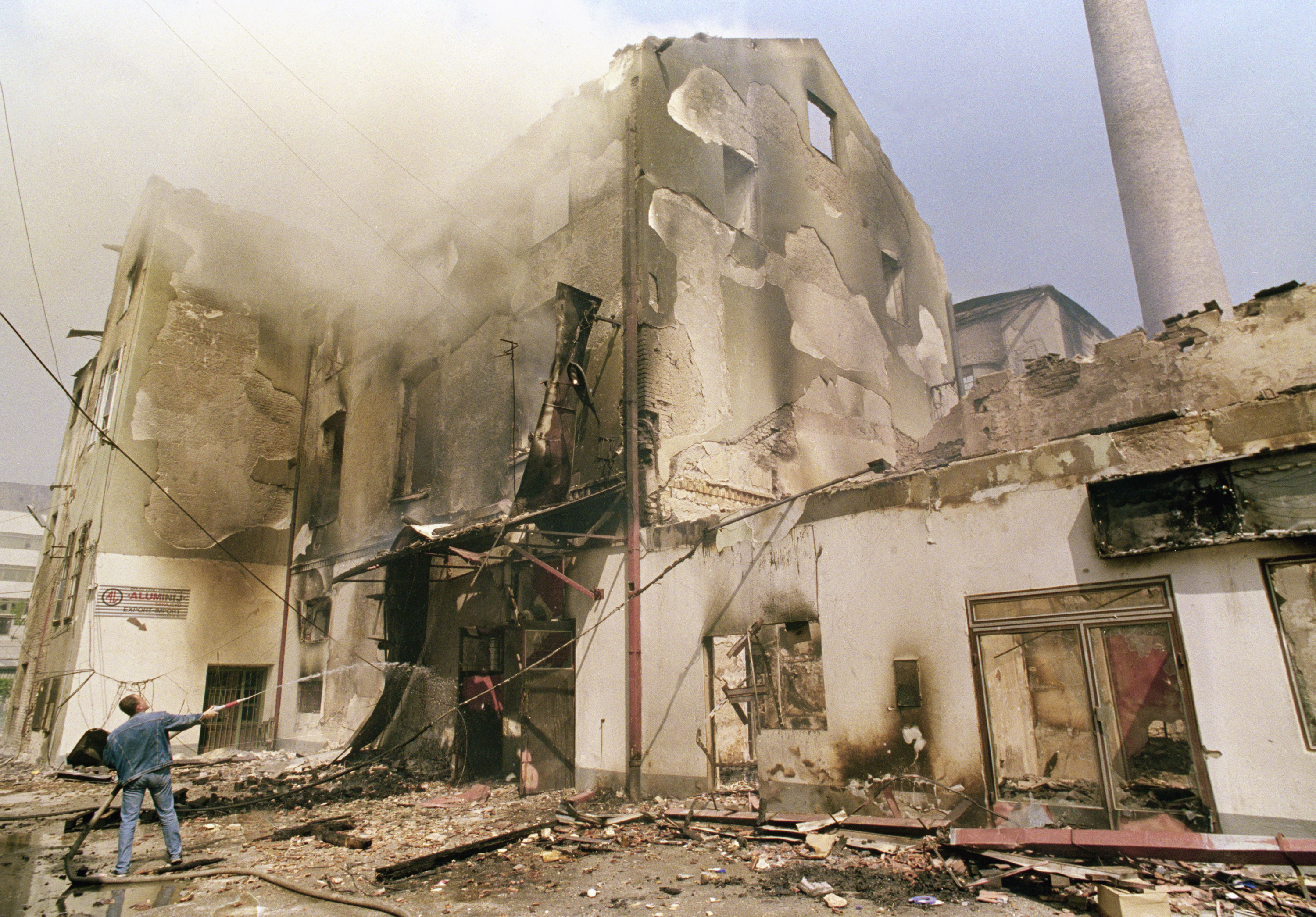 A man hoses a burning building in Sarajevo in 1992