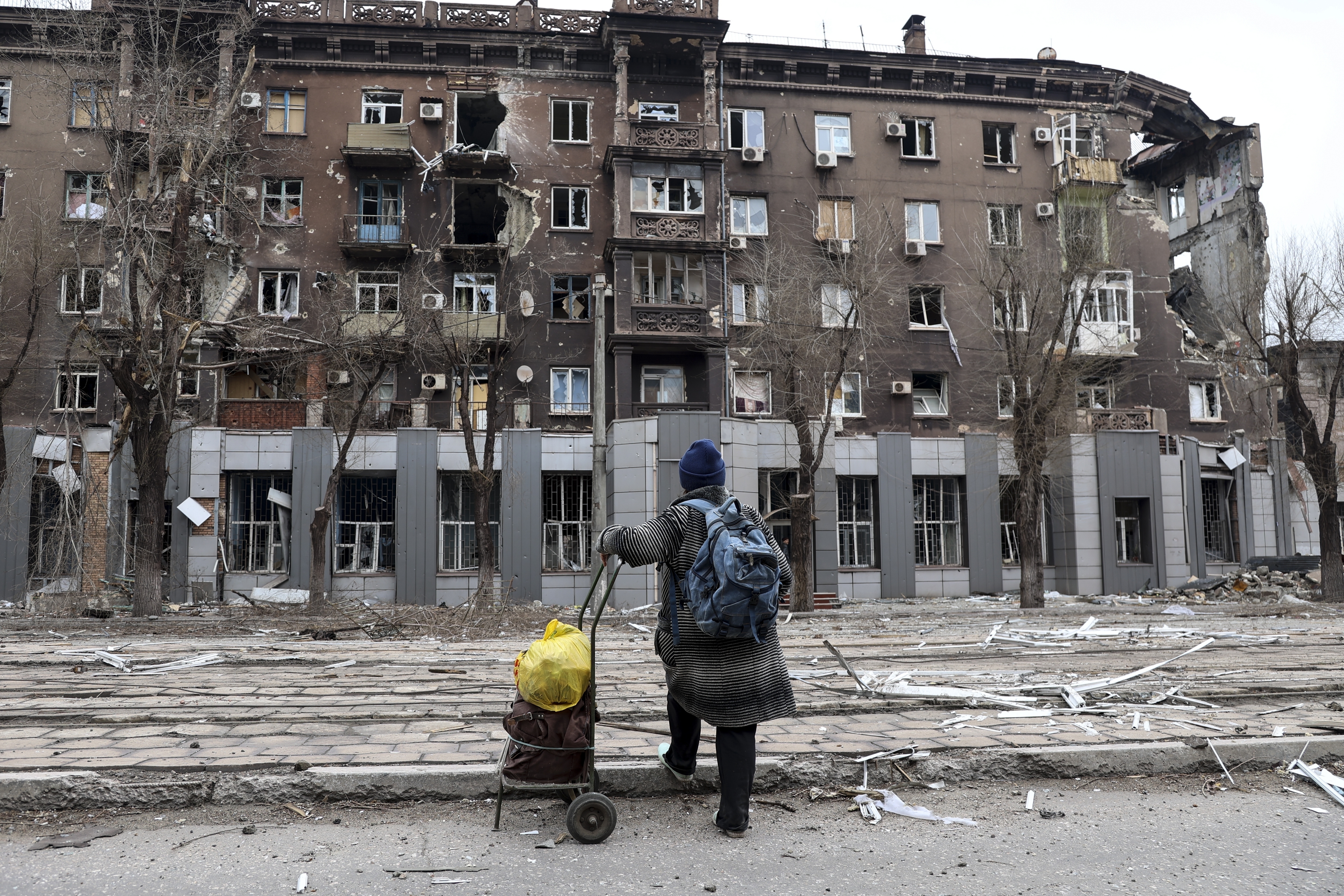 A local resident looks at a damaged during a heavy fighting apartment building