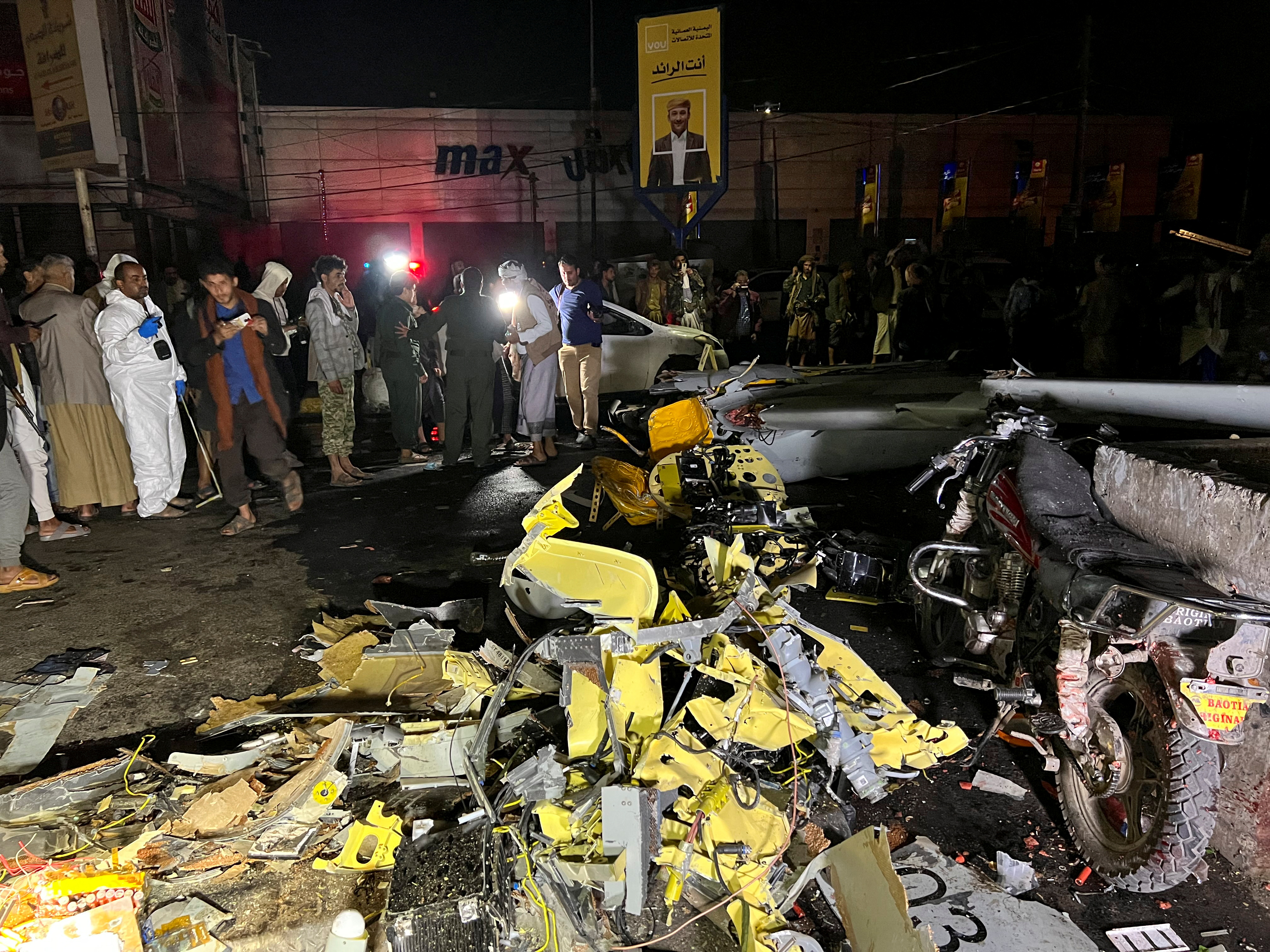 Residents and security personnel gather around the wreckage of a drone aircraft on a street in Sanaa, Yemen May 23, 2022.