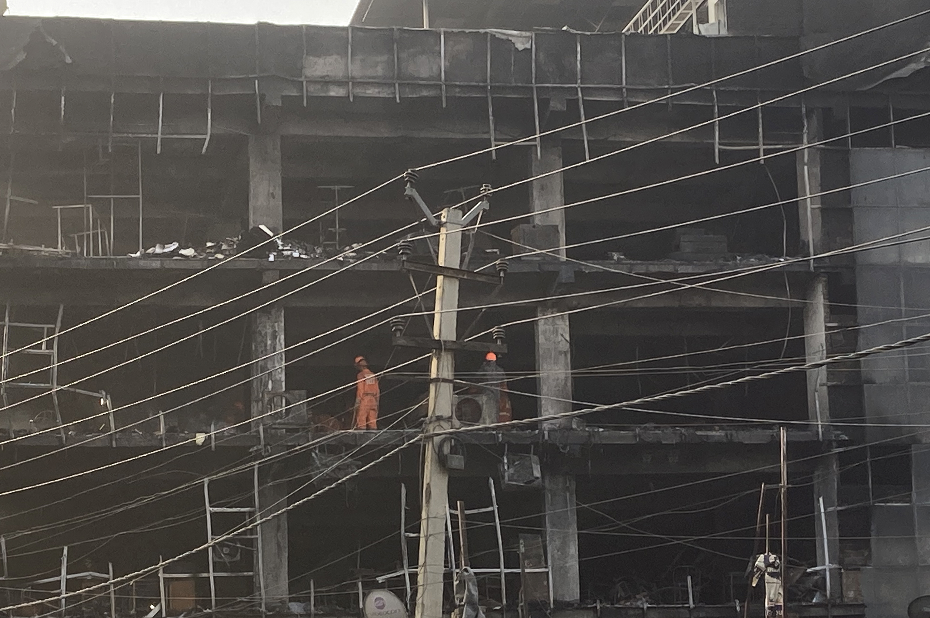 Rescuers work at the site of a fire in New Delhi, India, Saturday, May 14, 2022.