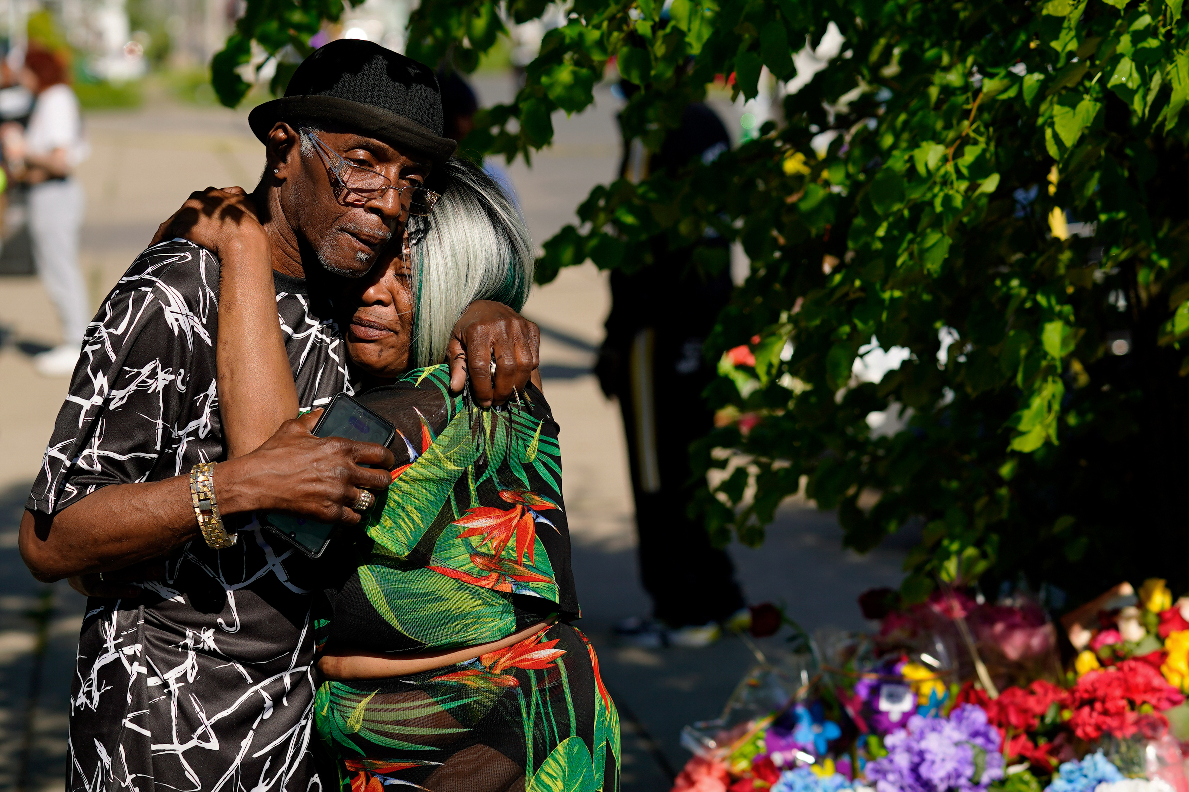 People embrace outside the scene of the racist mass shooting in Buffalo, New York.