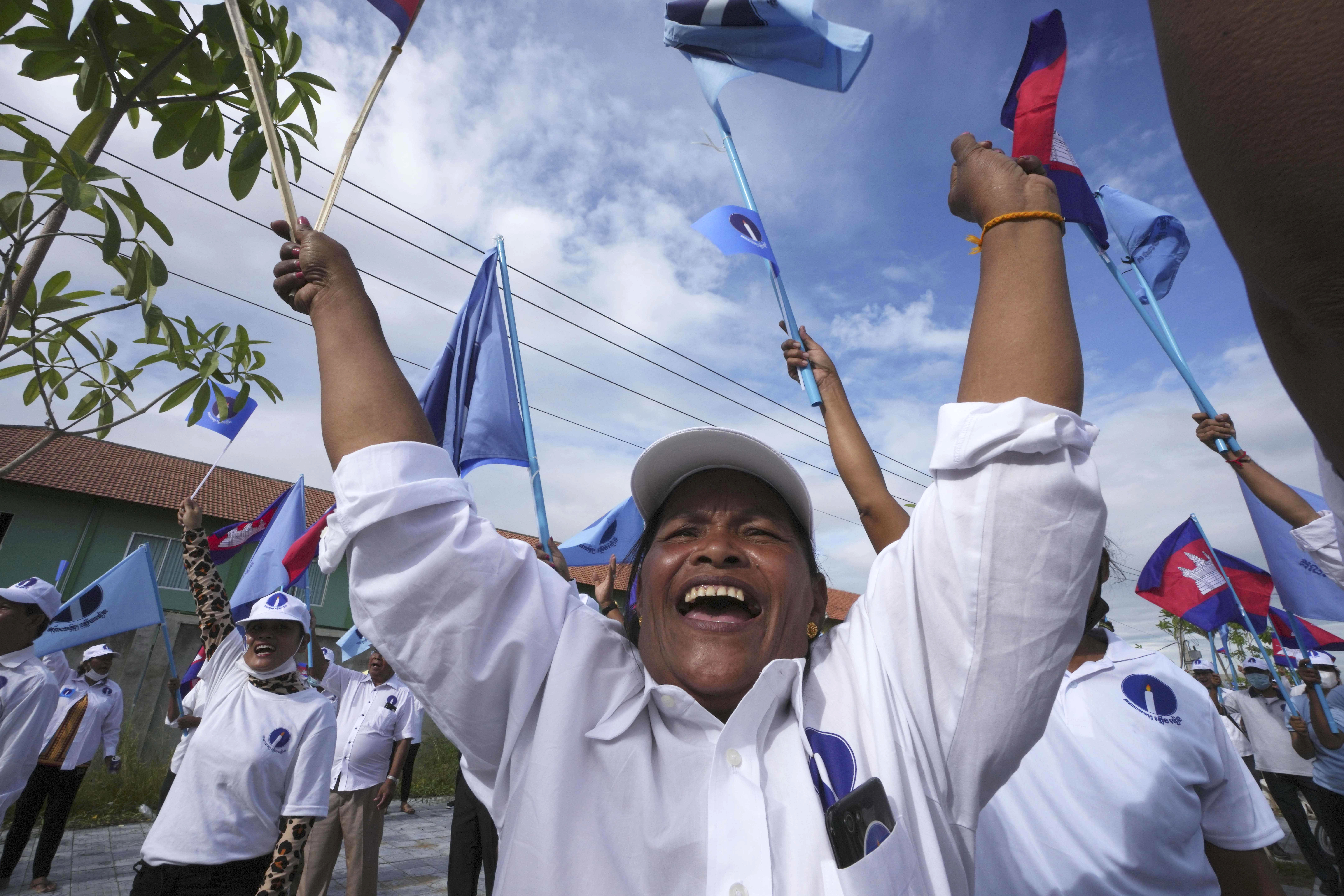 An opposition supporter smiles and holds his arms aloft at a rally for the opposition Candlelight Party