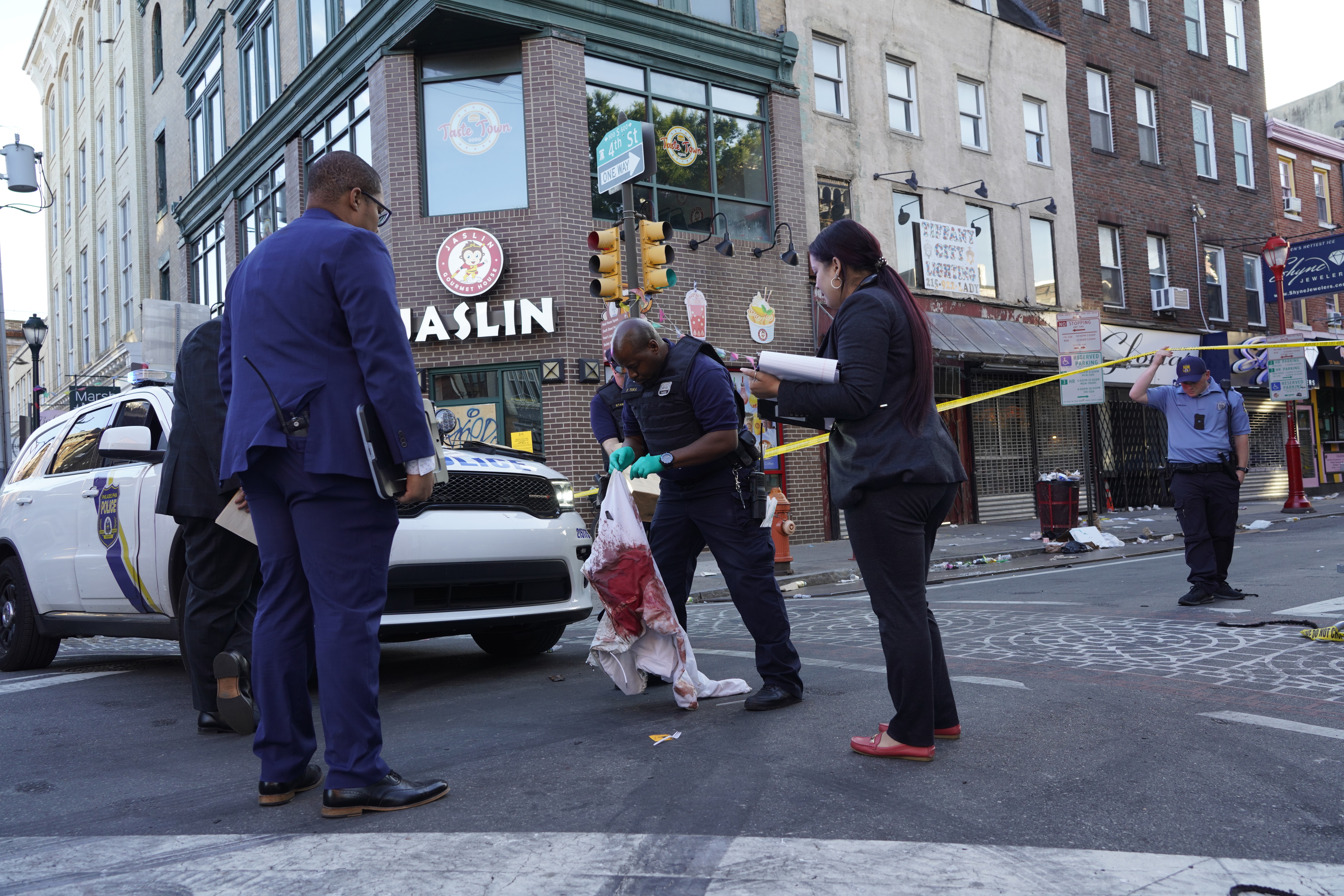 Philadelphia Police investigators work the scene of a fatal overnight shooting on South Street in Philadelphia.
