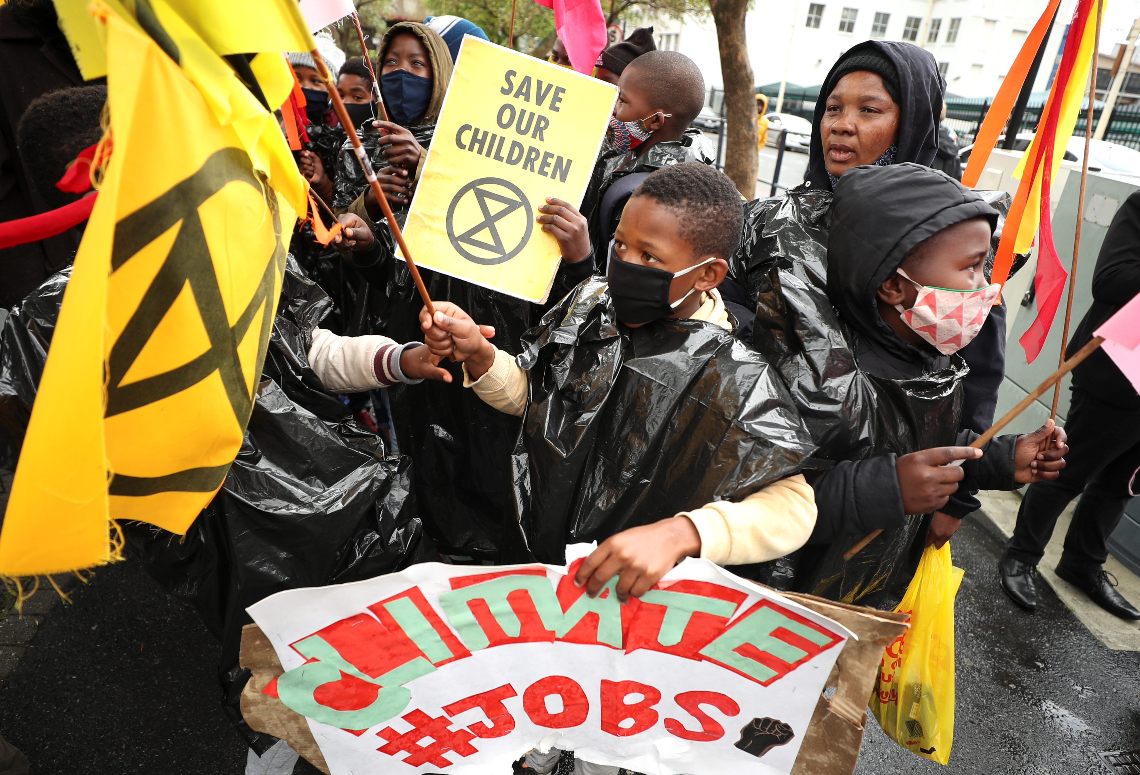 Protestors carry placards as they demonstrate as part of a global day of action on climate change outside parliament in Cape Town