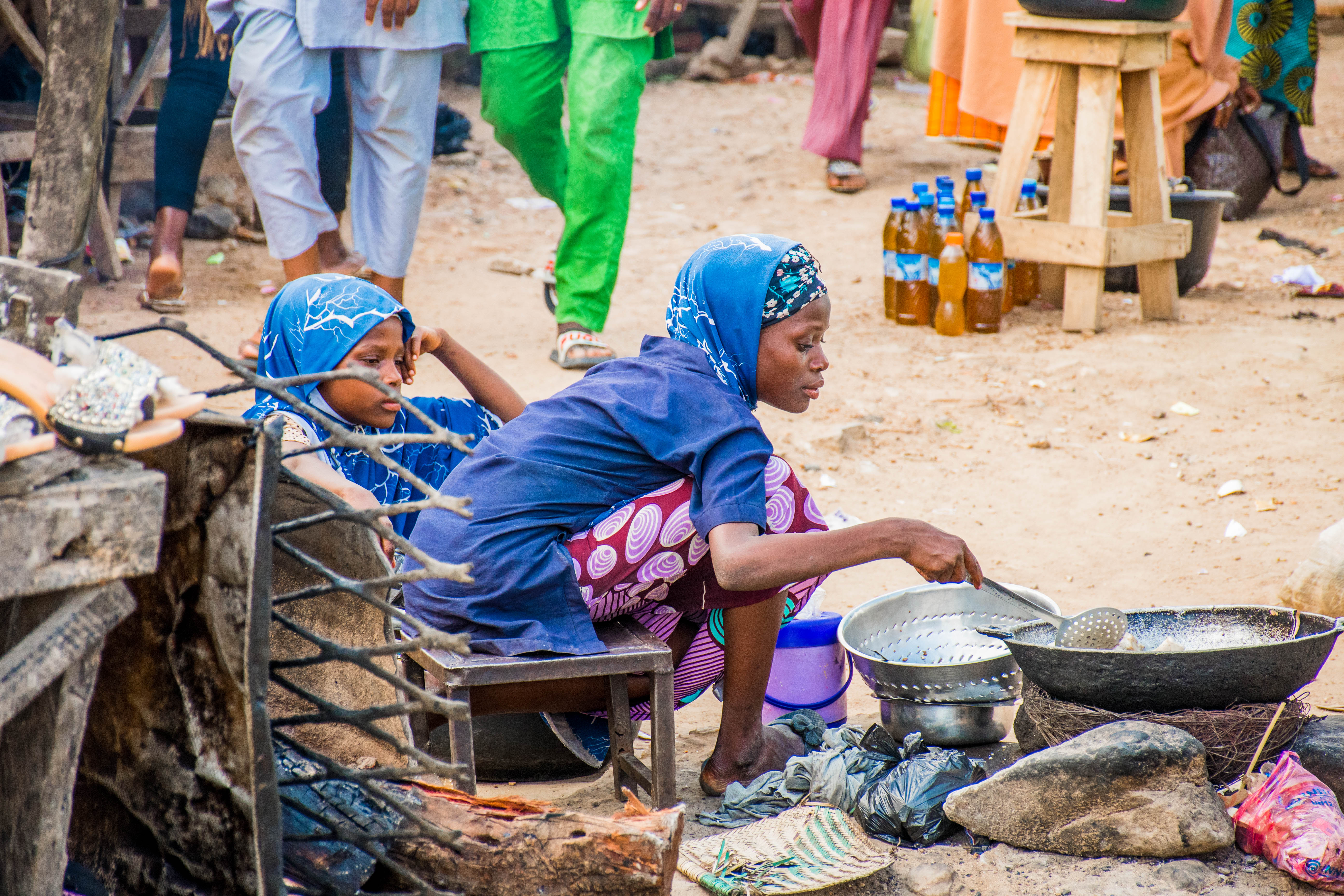 A Minna woman sells street food and cooks with her daughter nearby. Several of the women interviewed discussed how their children were the main motivation for their hustle. “Honestly, there was a time I wanted to quit,” Tabitha, a food vendor and seamstress, admitted. “But when I look at my daughter, I say, will I carry my money to go and buy something that I know that I can make? Instead of me to buy a new dress for her, I can make that same dress that I'm going to buy. So then let me repair my machine so that we continue…I think that is what makes me to stand up on my ground to continue from where I stopped.”
