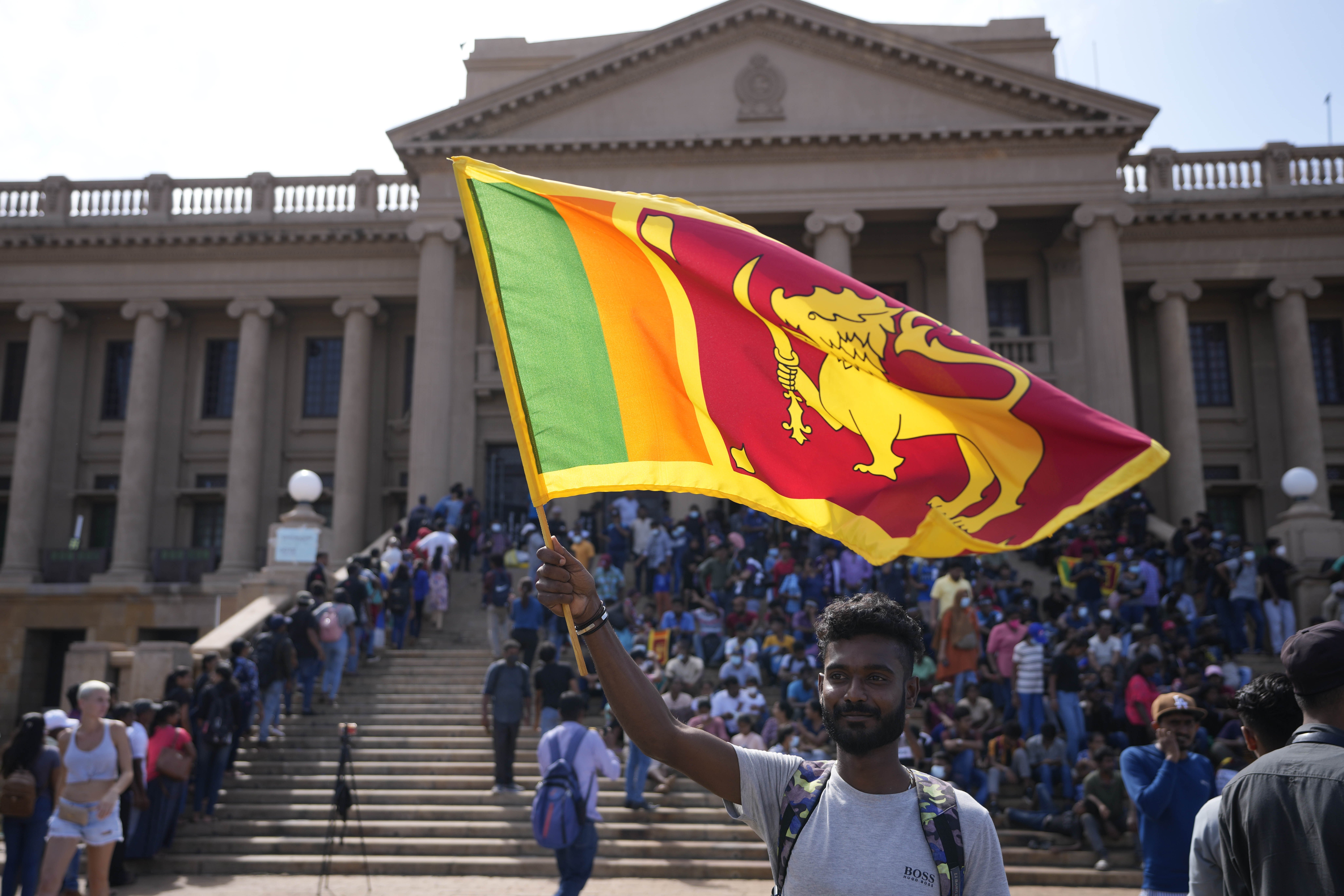A protester waves a national flag outside the president's office in Colombo, Sri Lanka.