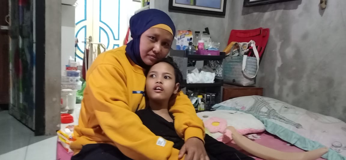 Warastuti embraces her daughter Peka at home