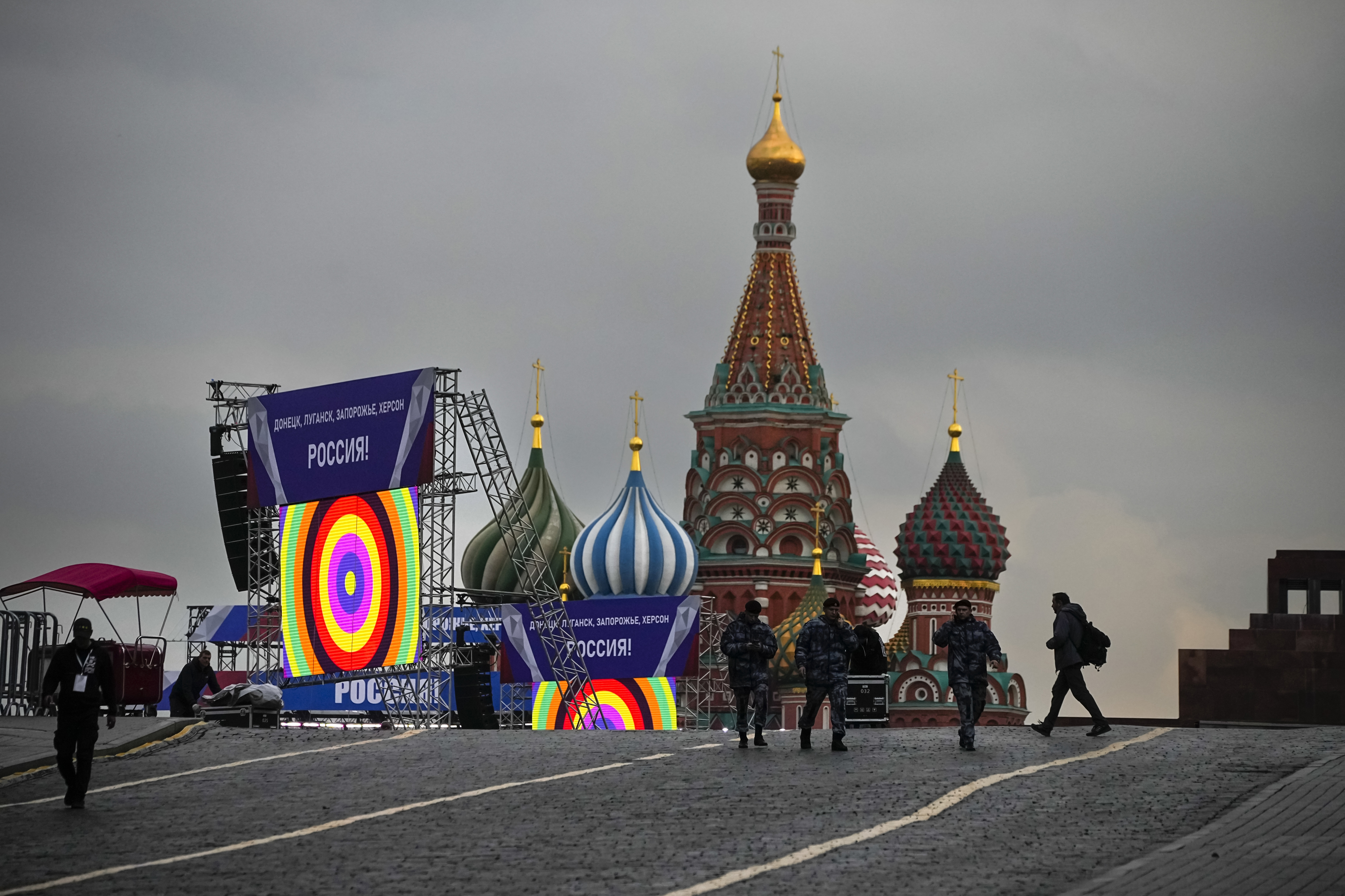 Police officers walk at Red Square in front of constructions reading the words ''Donetsk, Luhansk, Zaporizhzhia, Kherson, Russia'', with the St. Basil's Cathedral and Lenin Mausoleum in the background, ahead of a planned concert in Moscow, Russia, Thursday, Sept. 29, 2022. The Kremlin said that Russian President Vladimir Putin and the leaders of the four regions of Ukraine that held a referendum on joining Russia will attend a ceremony to sign documents on the regions' incorporation into Russia, which will be followed by a big concert on Red Square. (AP Photo/Alexander Zemlianichenko)