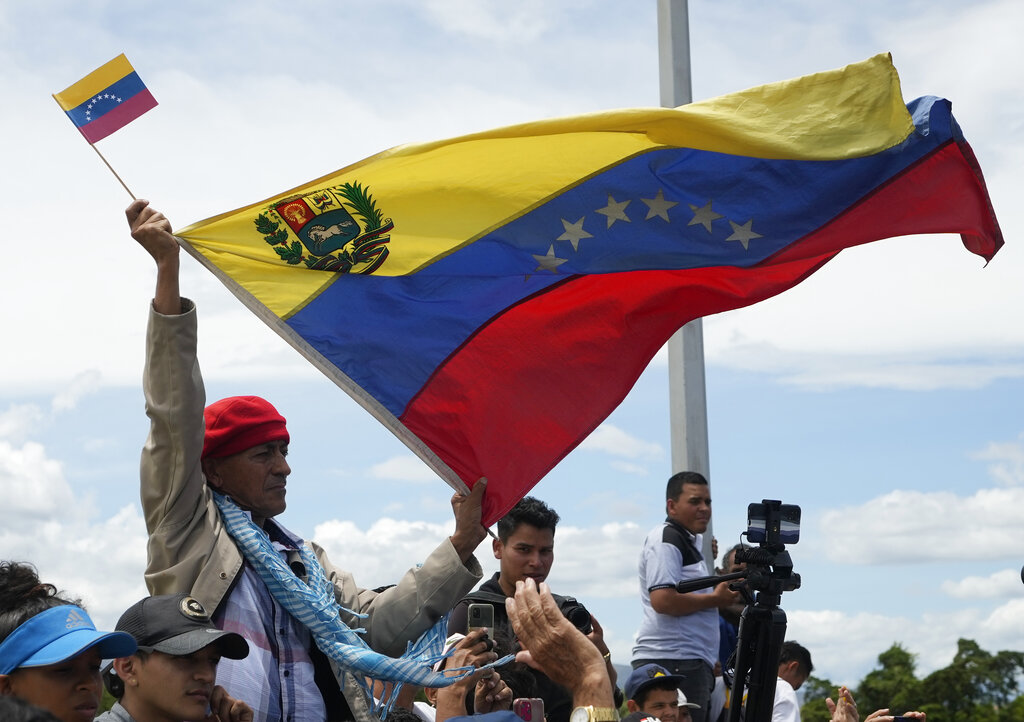 A man holds a Venezuelan flag as Venezuela and Colombia partially reopen their border