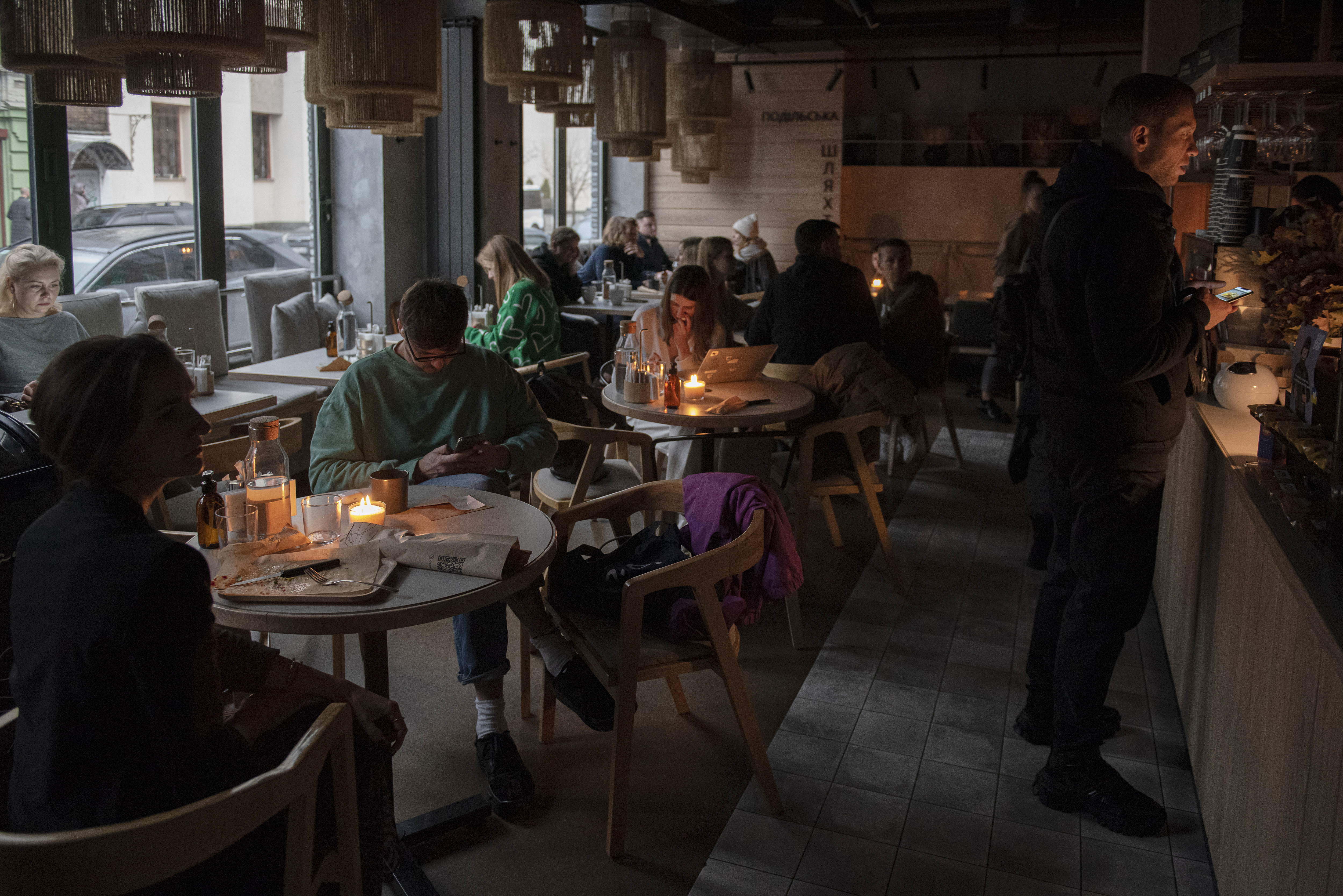 People sit in a cafe during a blackout in Kyiv.
