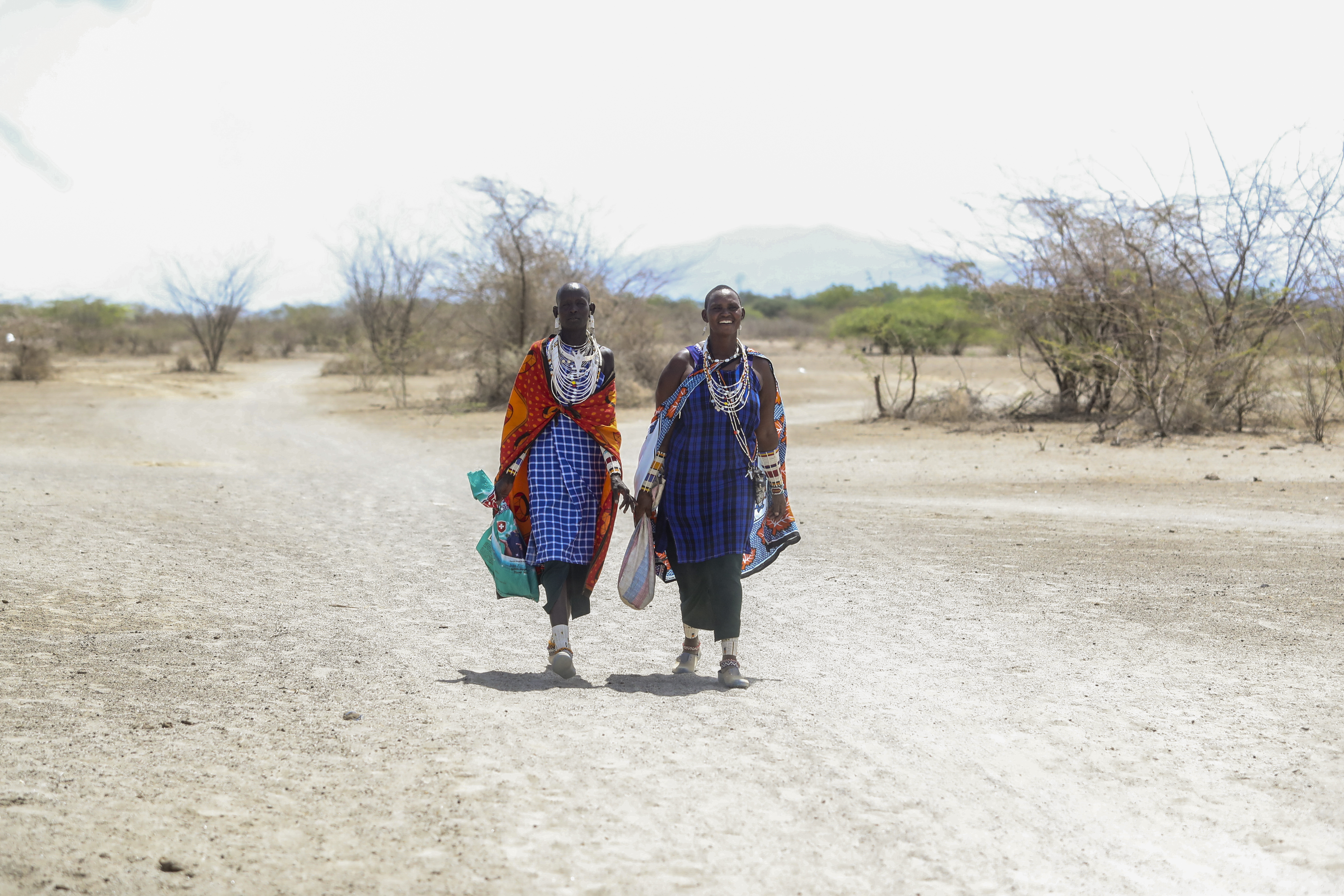 Two Maasai women walk back home from a market in Ol Kiramatian, near Lake Magadi, in Kenya.