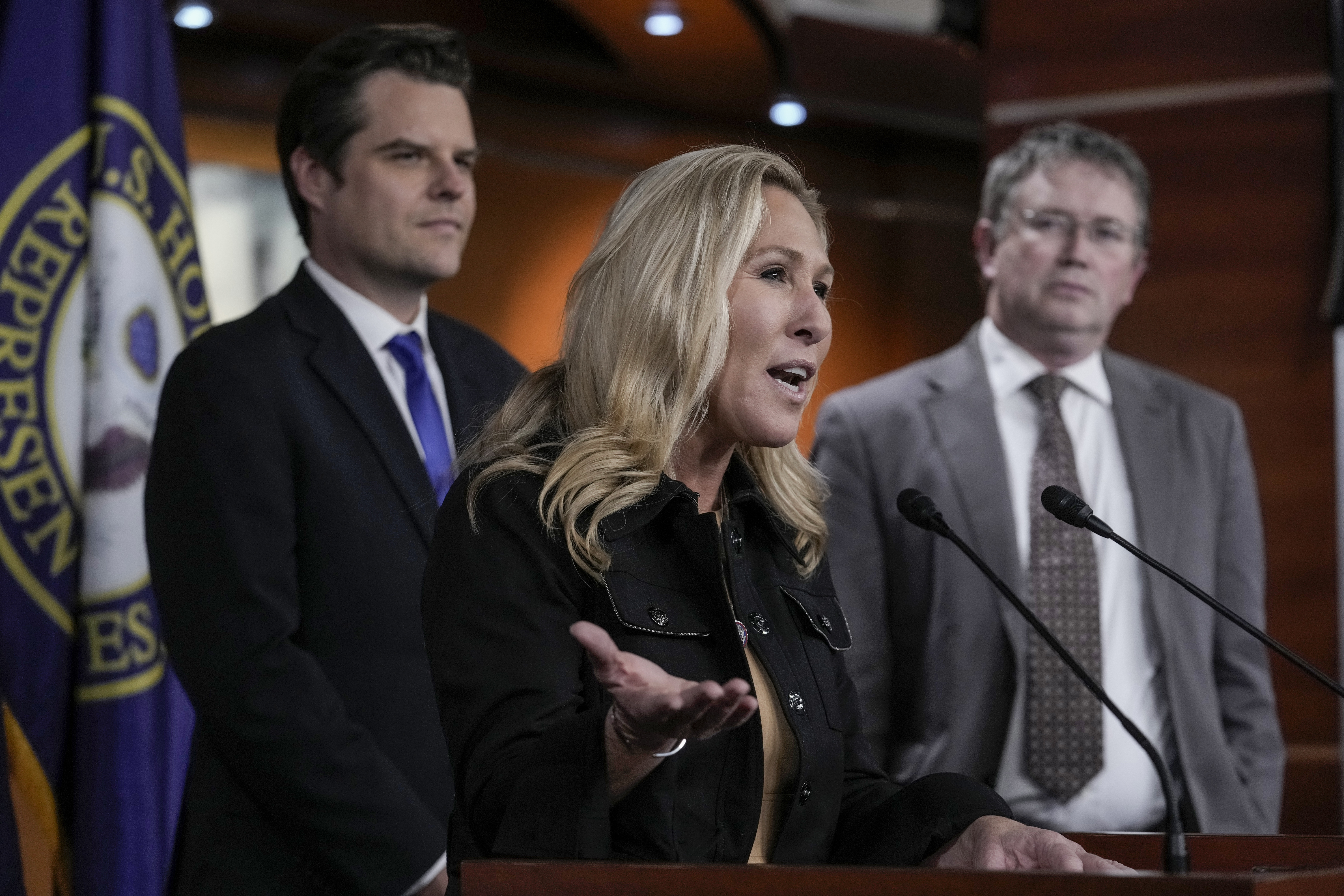 Green at podium with colleagues on either side