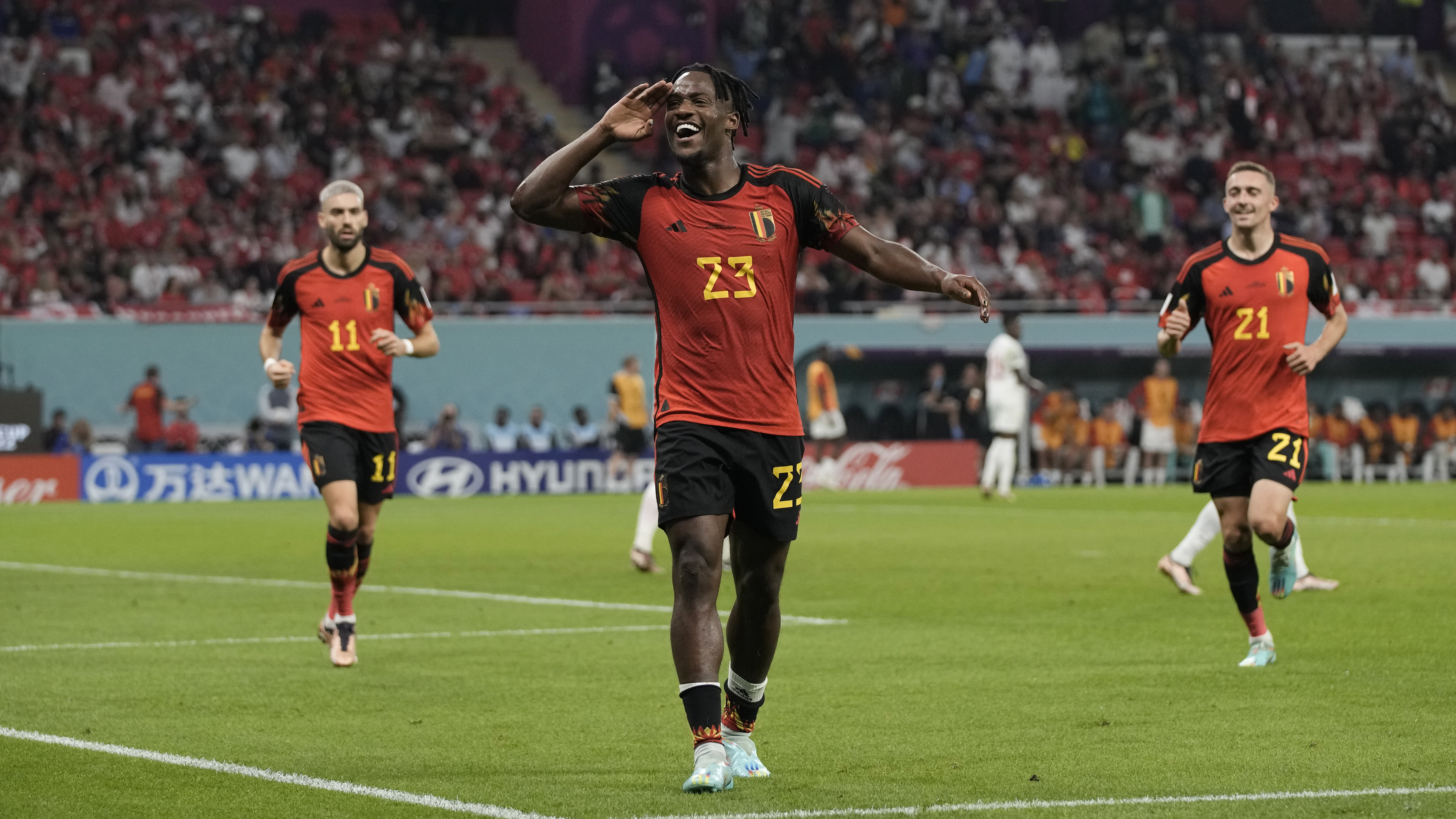 Batshuayi happy, in the middle of the field walking and holding