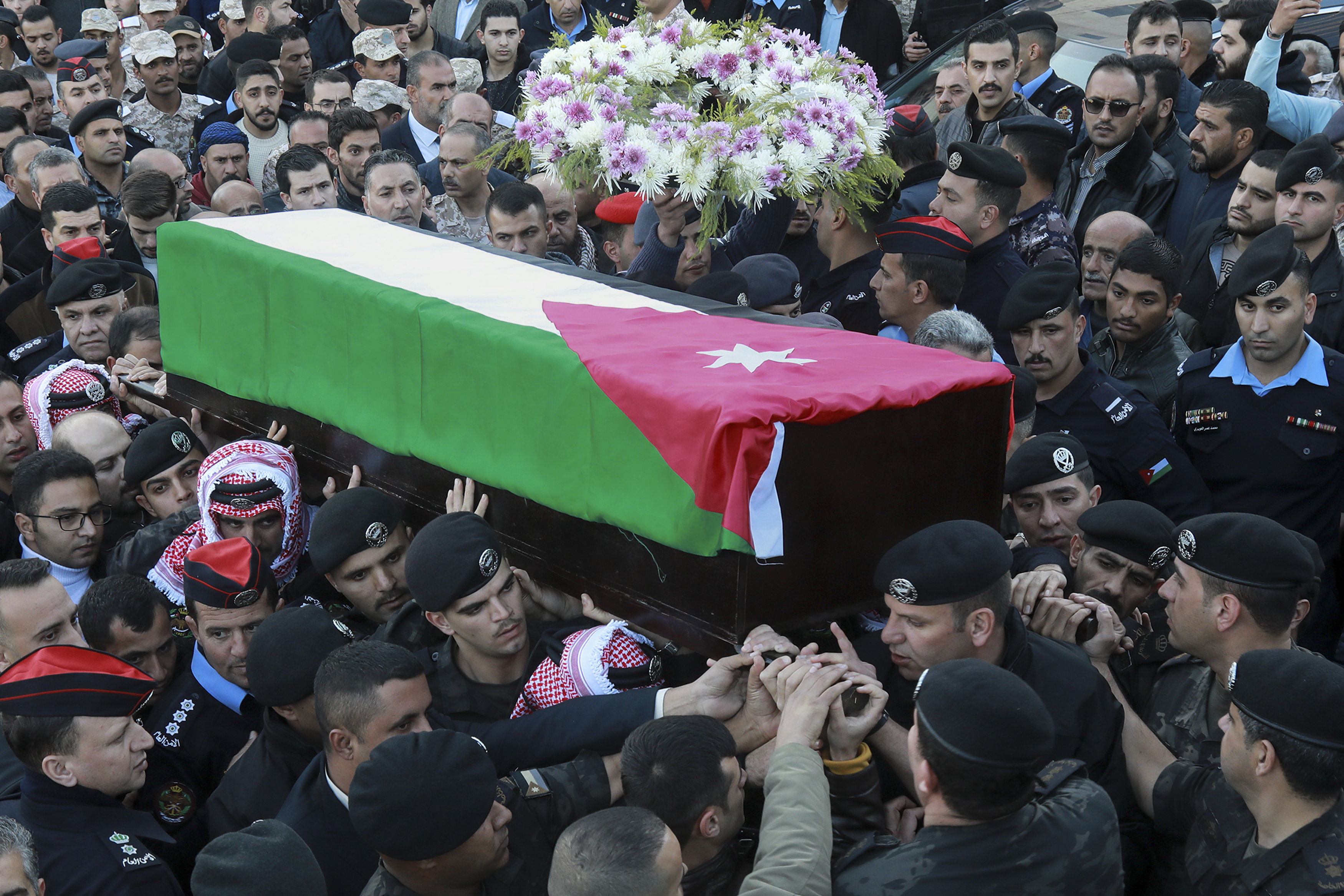 Friends and relatives carry the coffin of Captain Ghaith Al-Rahahleh, a Jordanian police officer who was killed in a shootout during his funeral in Amman, Jordan, Monday, Dec. 19, 2022.