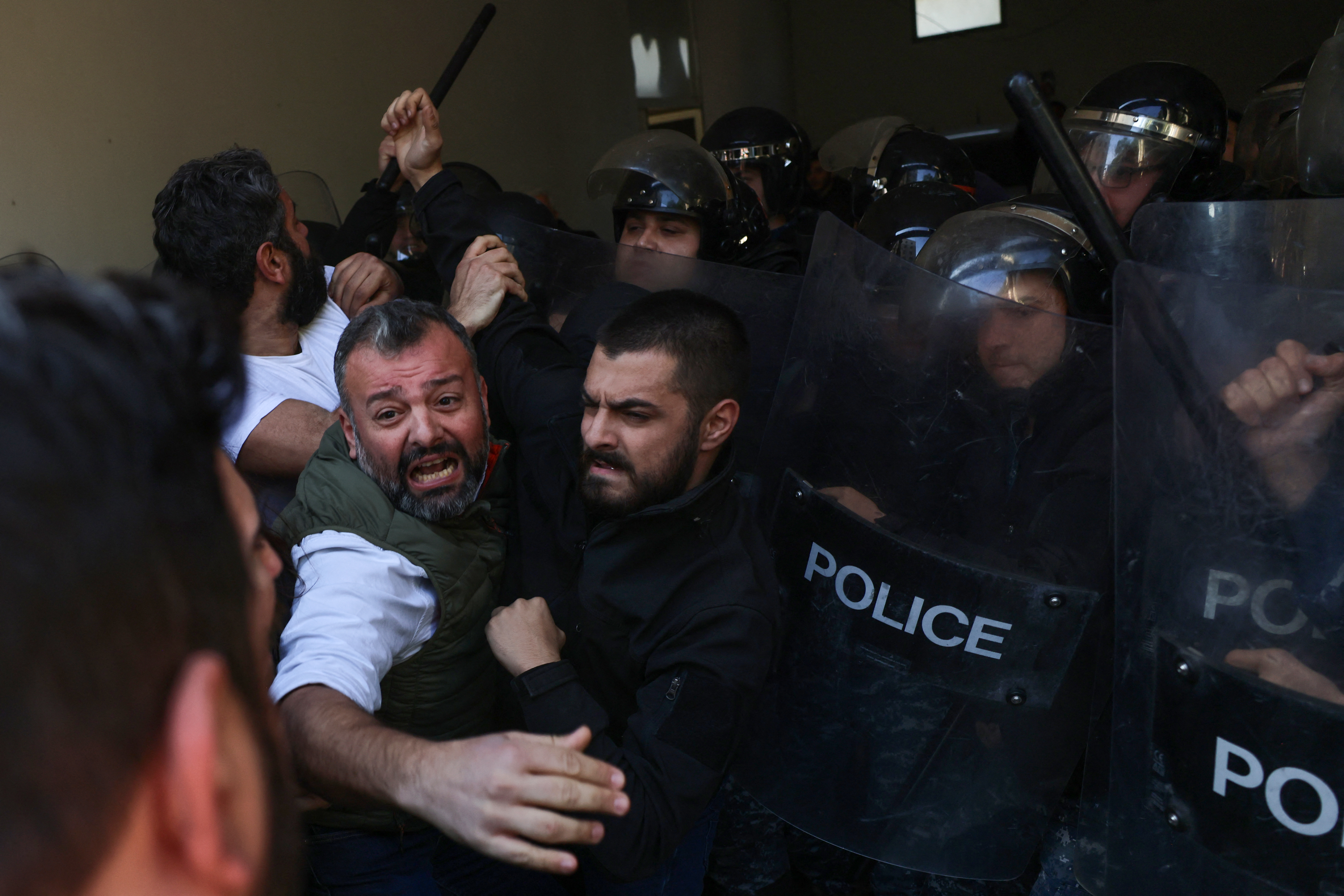 Security forces push back relatives of victims of the 2020 Beirut port explosion, trying to push their way into the palace of justice after breaking the lock of the entrance gate, during a rally outside the building in the Lebanese capital Beirut, to support the judge investigating the disaster, on January 26, 2023, after he was charged by the country's top prosecutor in the highly political case. - One of history's biggest non-nuclear explosions, the August 4, 2020 blast destroyed much of the Lebanese capital's port and surrounding areas, killing more than 215 people and injuring over 6,500. No official has been held accountable for the disaster. (Photo by Joseph EID / AFP)