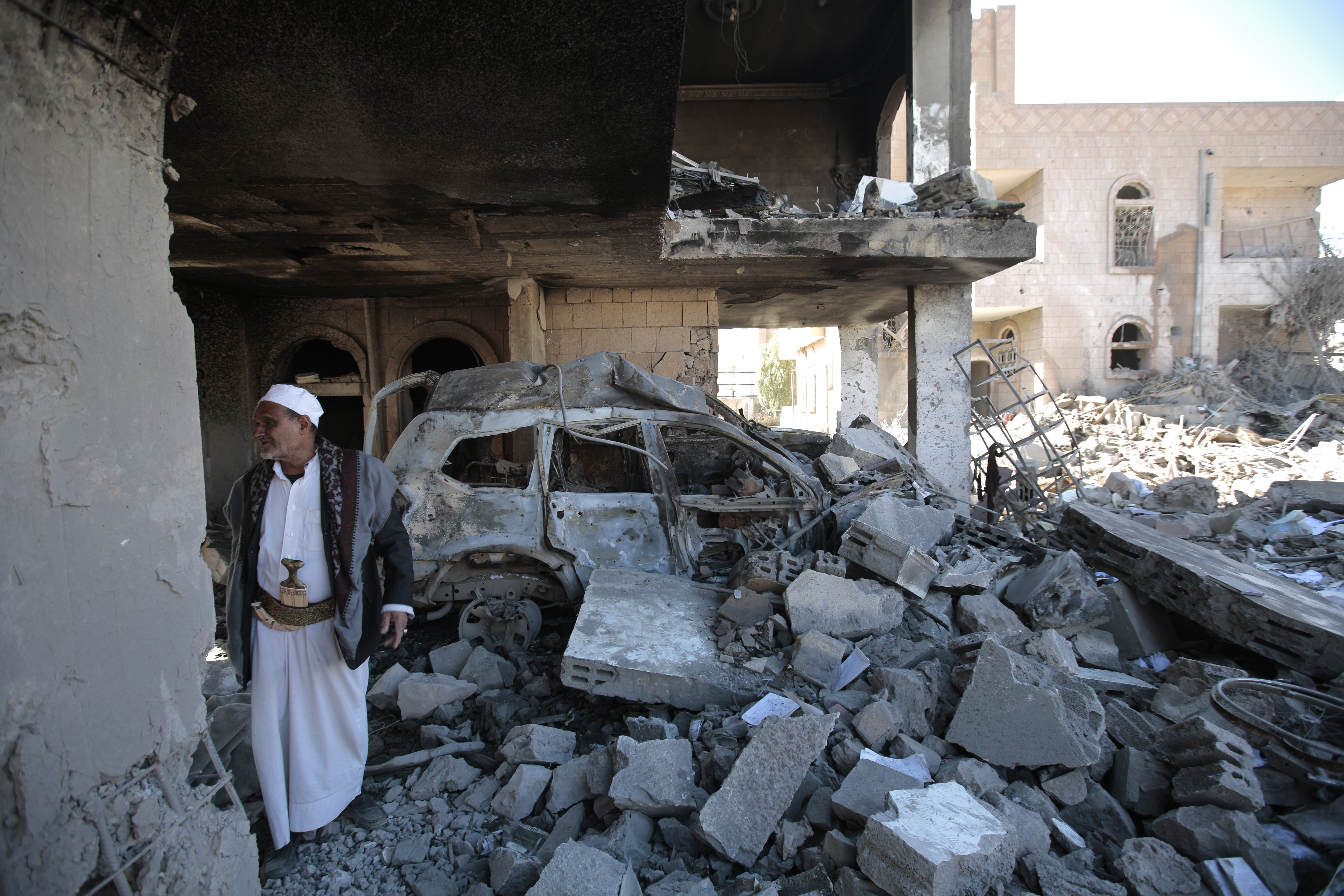 A man inspects the wreckage of a building in Sanaa