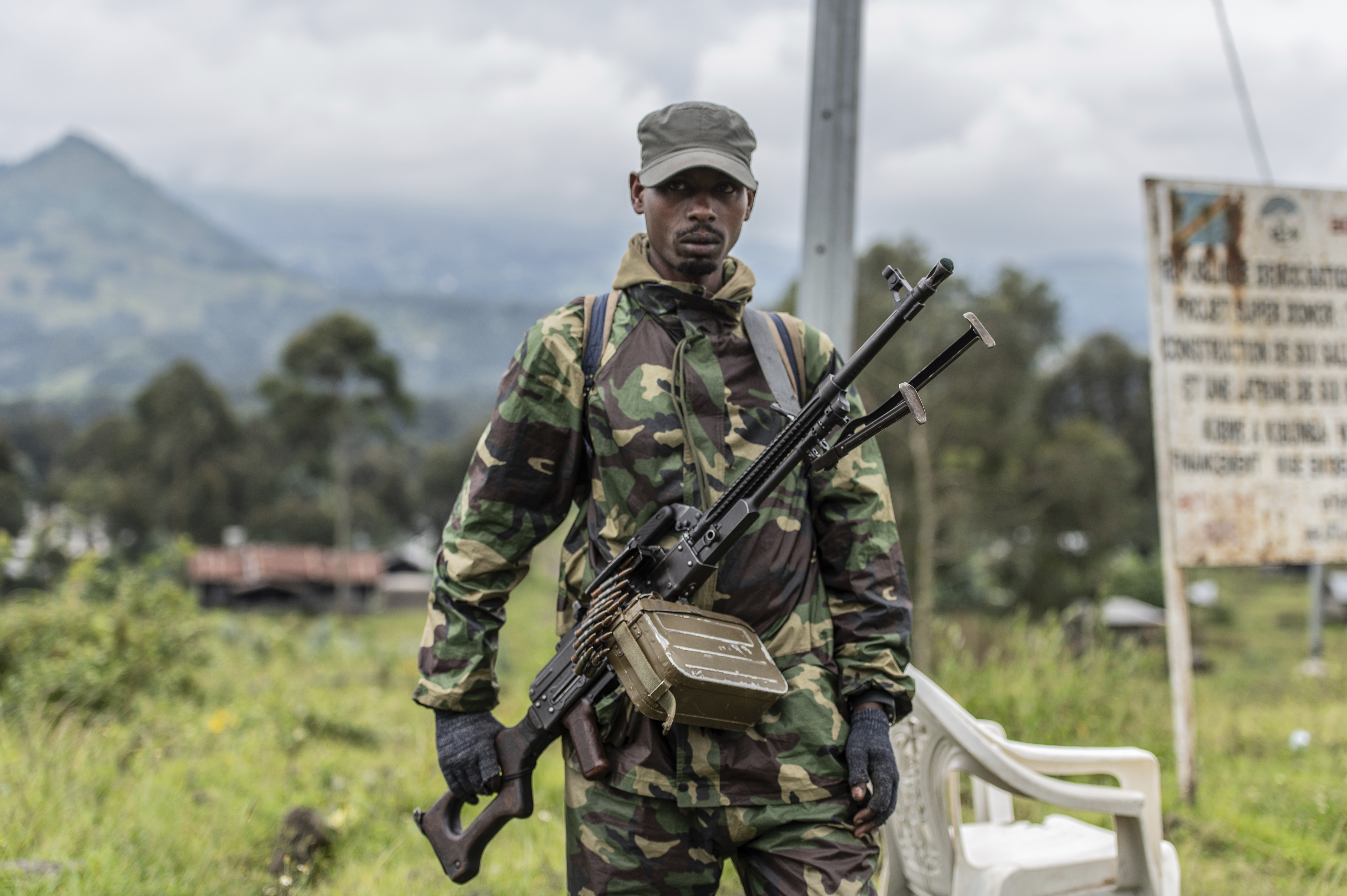 A M23 rebel stands with his weapon during a ceremony to mark the withdrawal from their positions in the town of Kibumba.