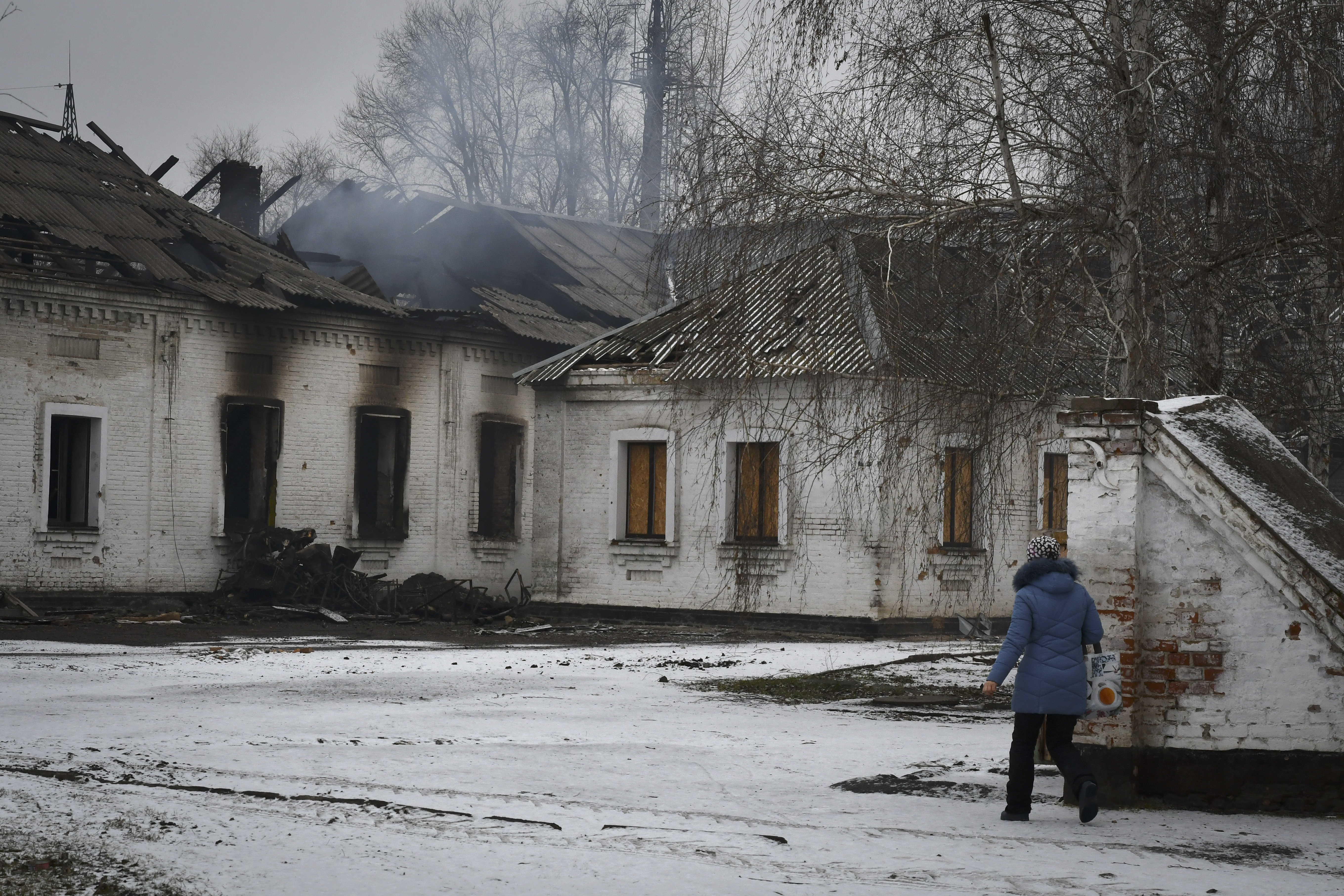 A resident walks past the bombed-out smouldering ruins of a school that was damaged by Russian shelling in the town of Orikhiv in the Zaporizhia region, Ukraine.