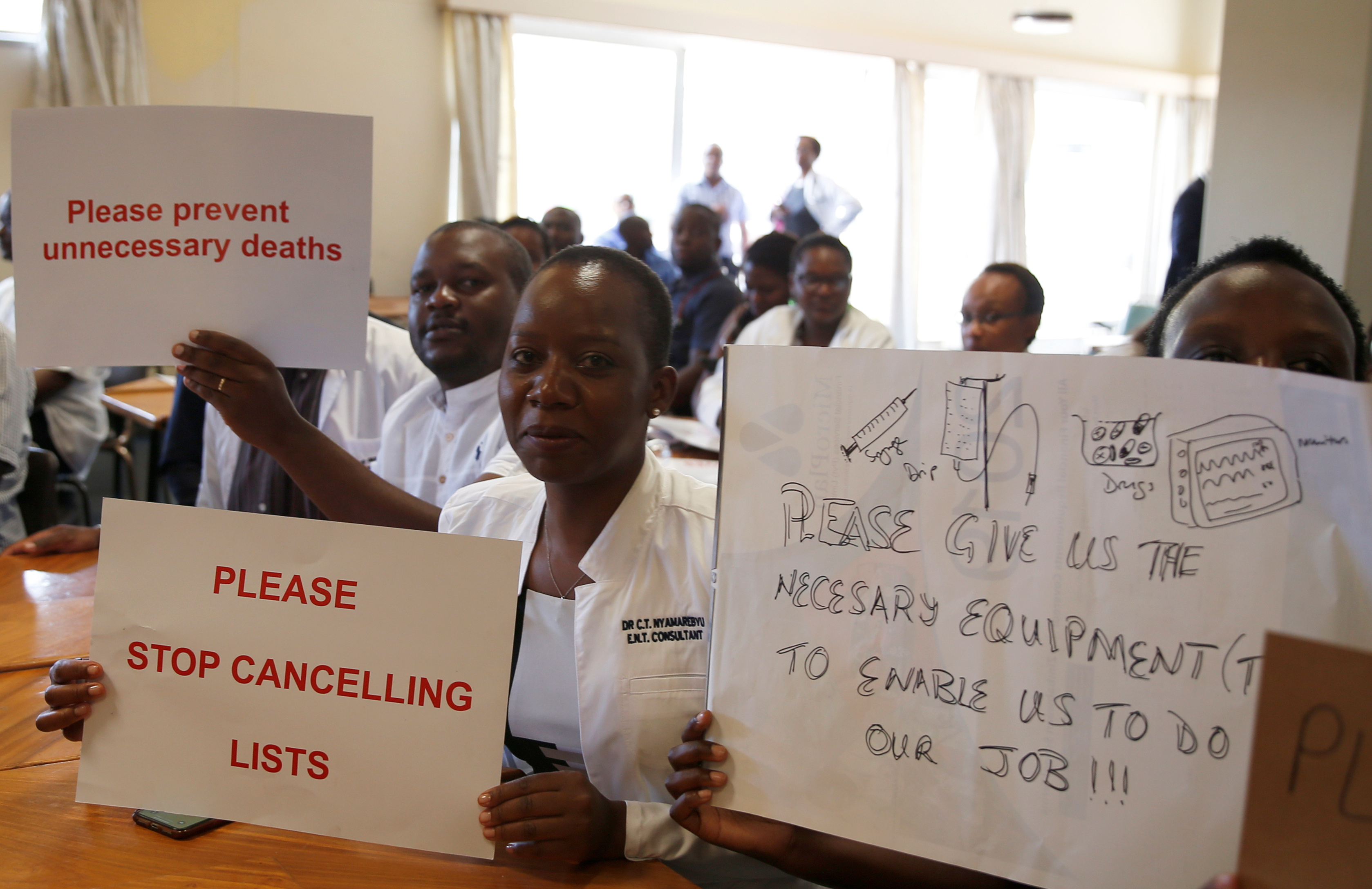 Senior doctors at Parirenyatwa General Hospital, Zimbabwe's biggest medical centre, hold placards during a demonstration to protest a lack of medicines, gloves and bandages in Harare, Zimbabwe March 13, 2019. REUTERS/Philimon Bulawayo