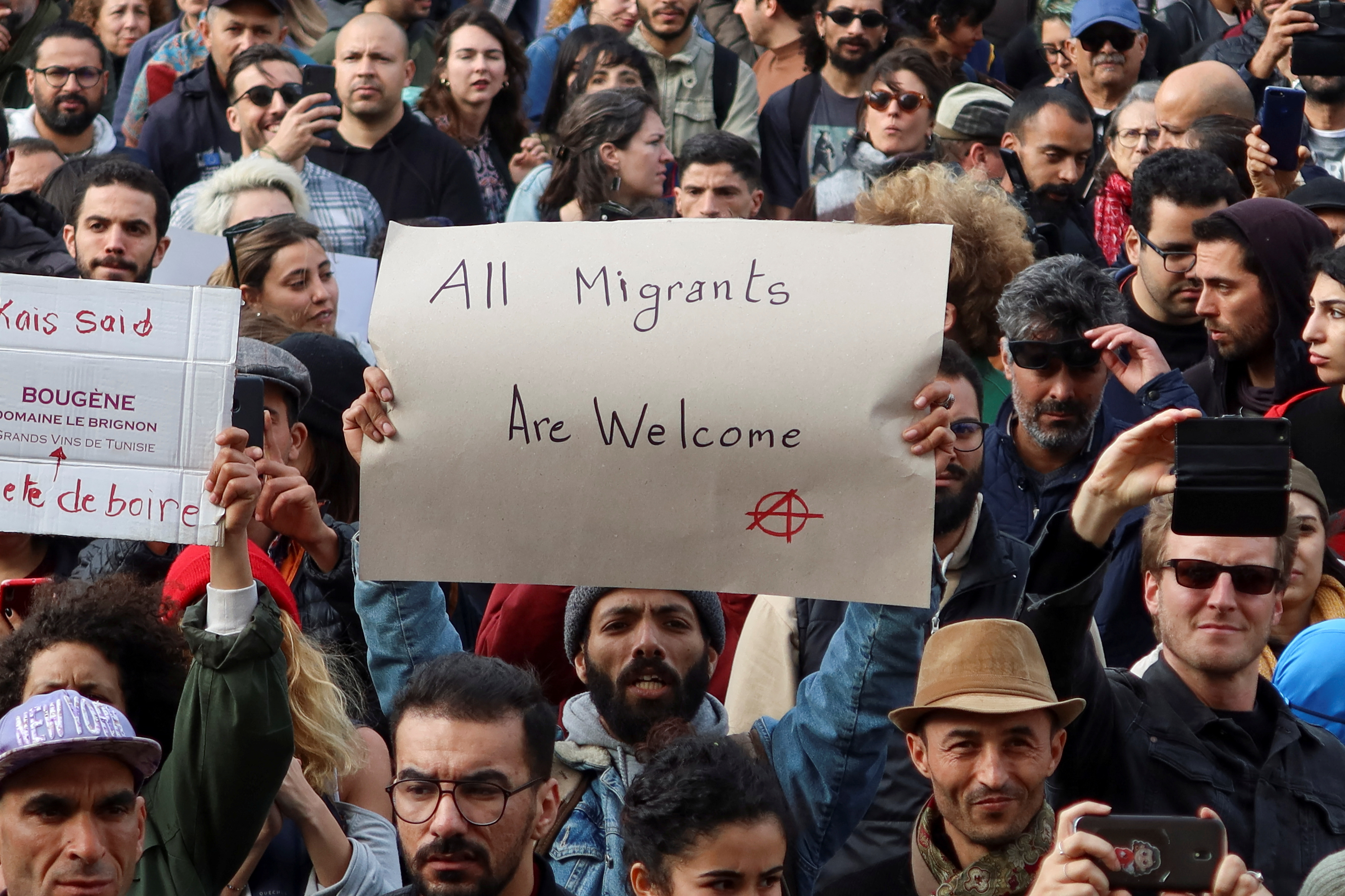 Members of rights groups carry banners during a protest, after Tunisian President Kais Saied ordered security forces to stop all illegal migration and expel all undocumented migrants, in Tunis, Tunisia February 25, 2023