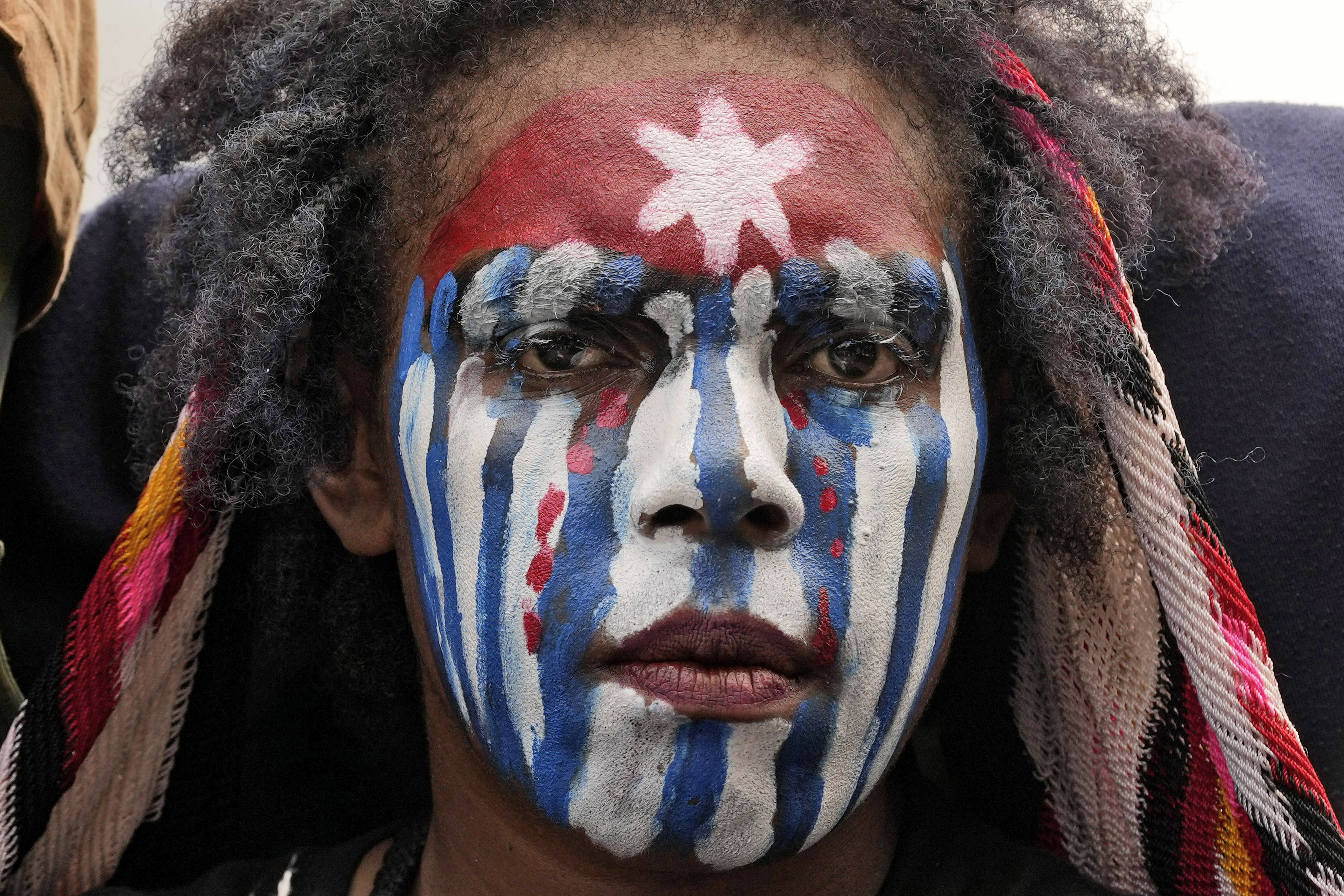 A close up of a Papuan student at a demonstration in Jakarta. The have painted their face in the red, white and blue of the independence movement's 'Morning Star' flag