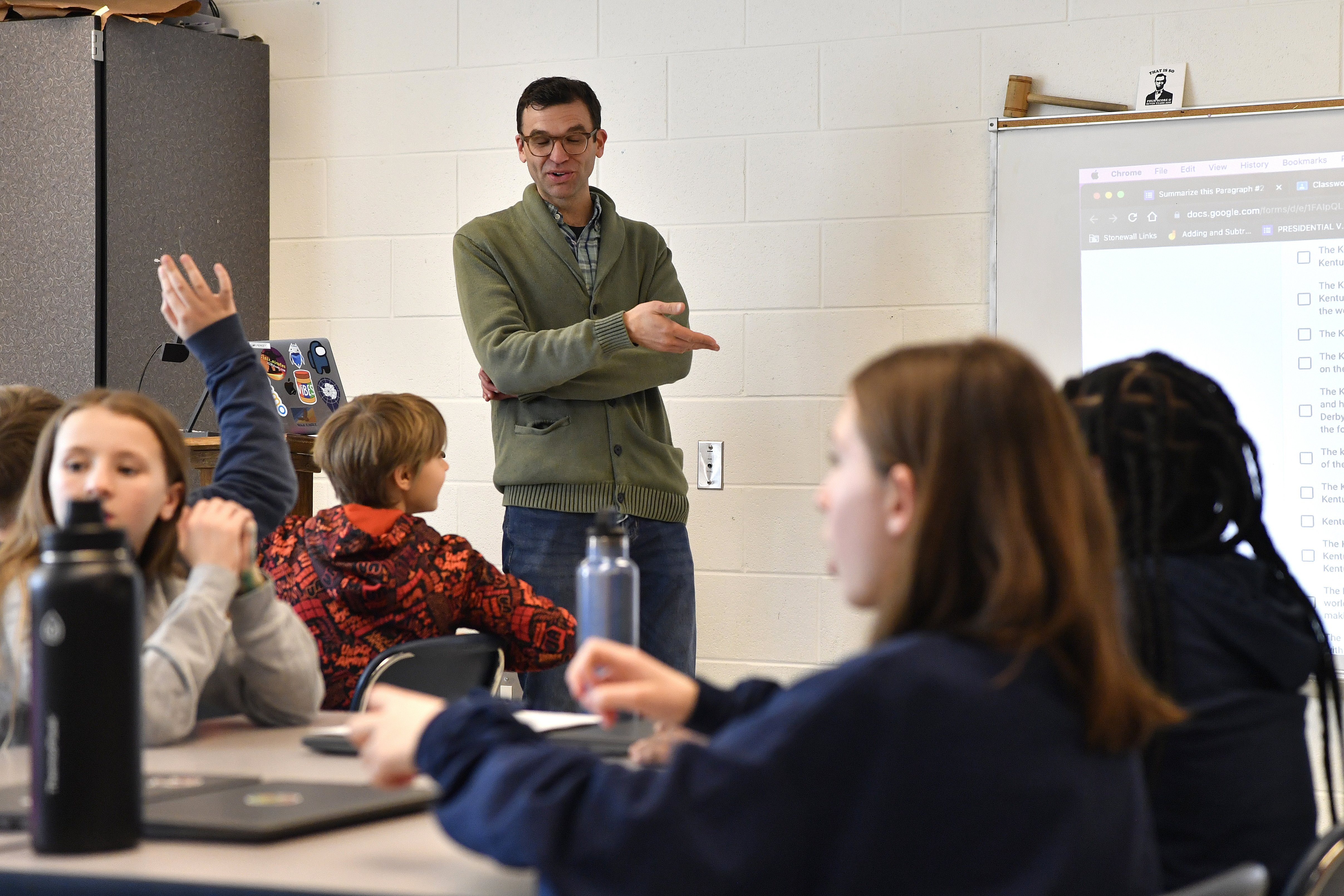 Teacher Donnie Piercey goes over the results of a writing assignment called "Find the Bot" during his class at Stonewall Elementary in Lexington, Ky., Monday, Feb. 6, 2023. The students each summarized a text about boxing champion and Kentucky icon Muhammad Ali then tried to figure out which summaries were penned by classmates and which was written by the chatbot. The chatbot was the new artificial intelligence tool ChatGPT, which can generate everything from essays and haikus to term papers in a matter of seconds. (AP Photo/Timothy D. Easley)