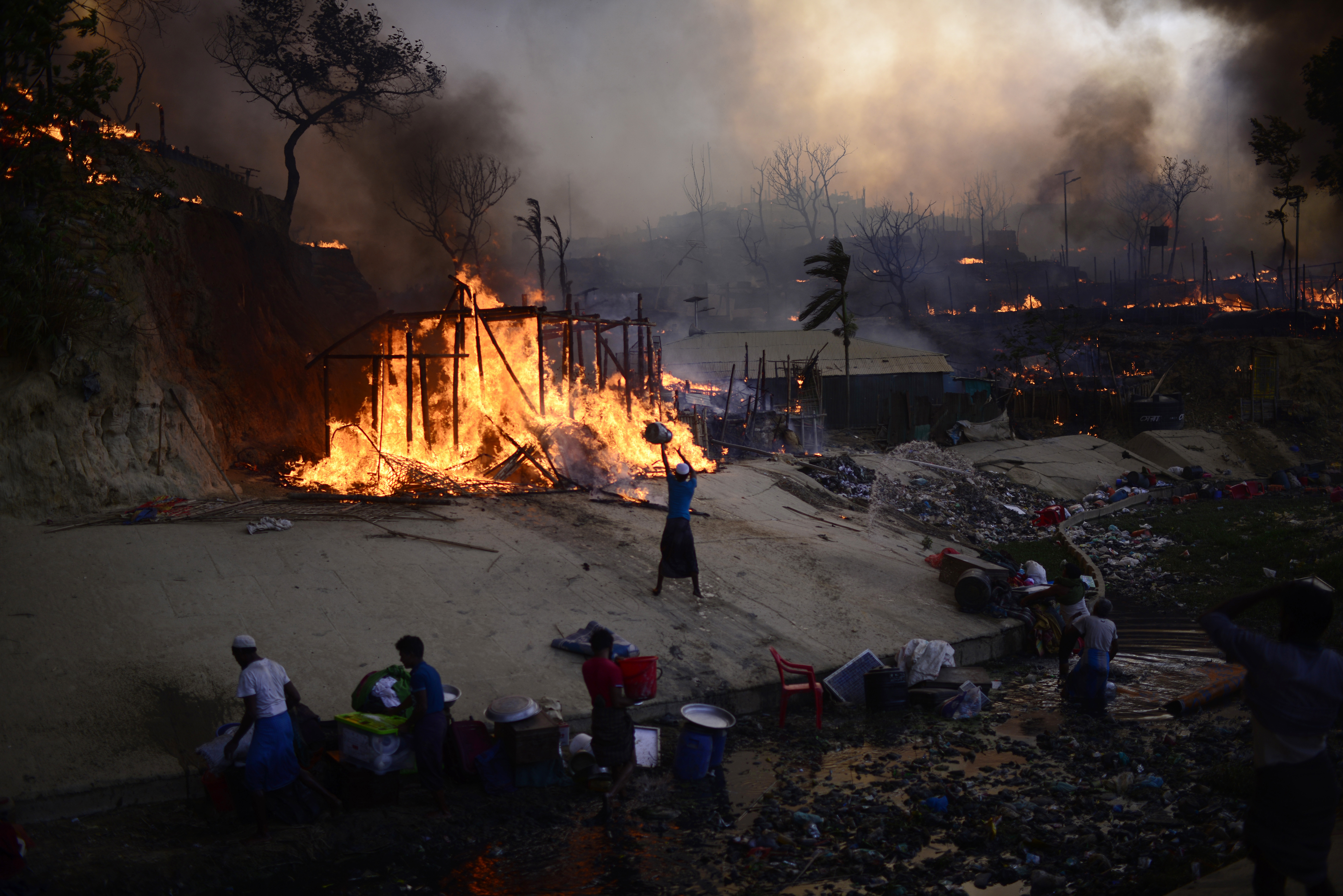 Rohingya refugees try to douse a major fire in their Balukhali camp at Ukhiya in Cox's Bazar district, Bangladesh